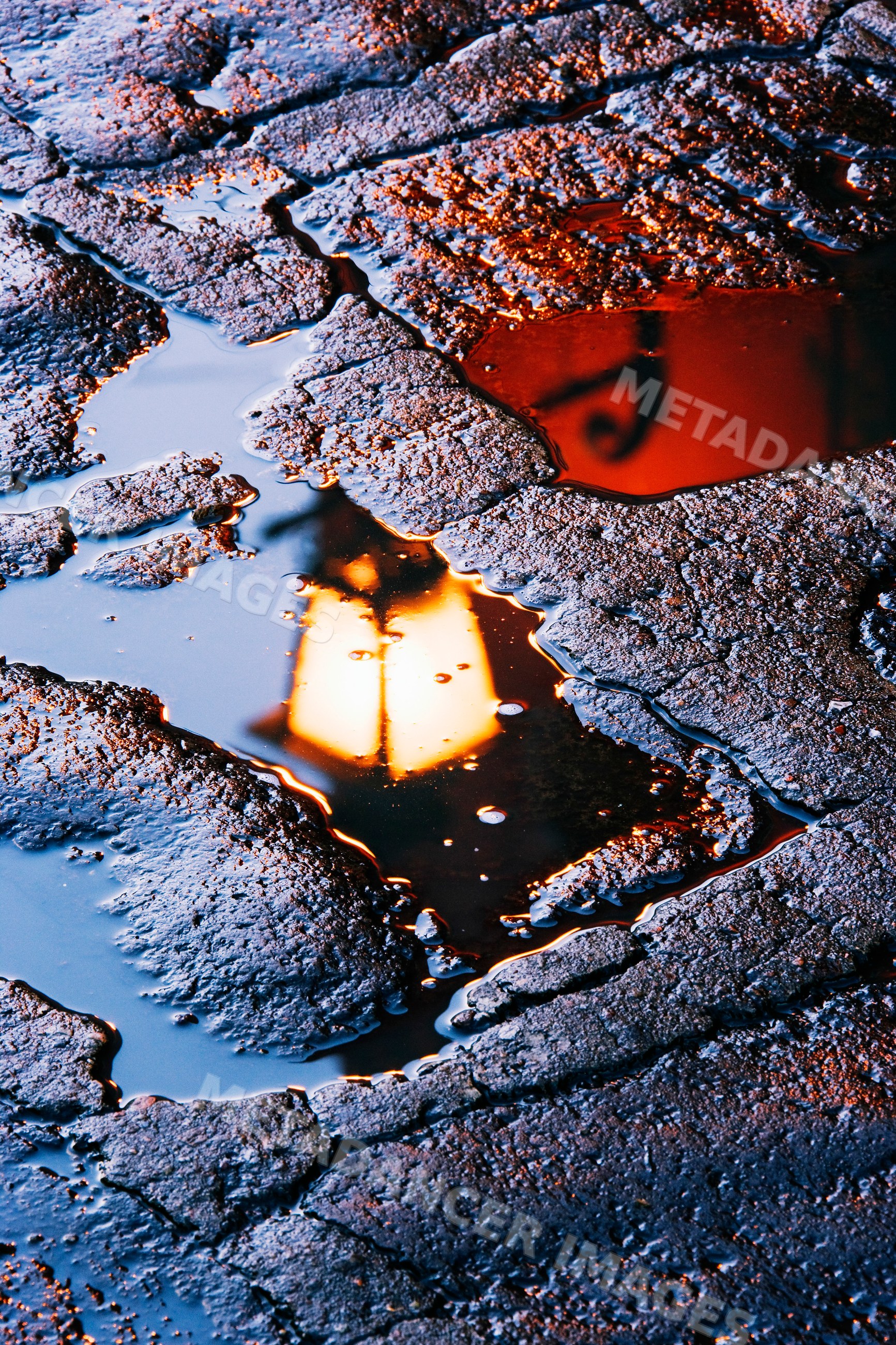 Reflection of street lamp on wet asphalt street
