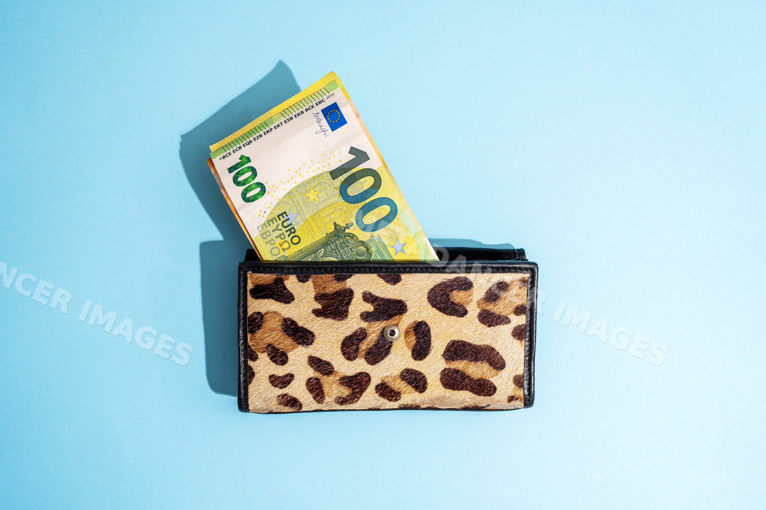 Wallet with 100 euro banknotes on blue background