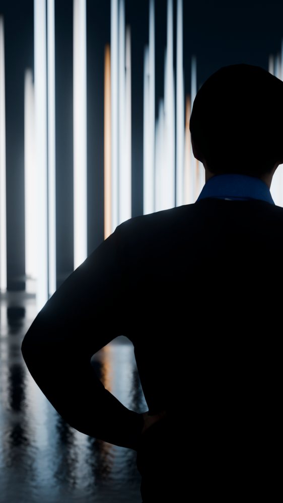 Silhouette of man facing vertical light beams indoors