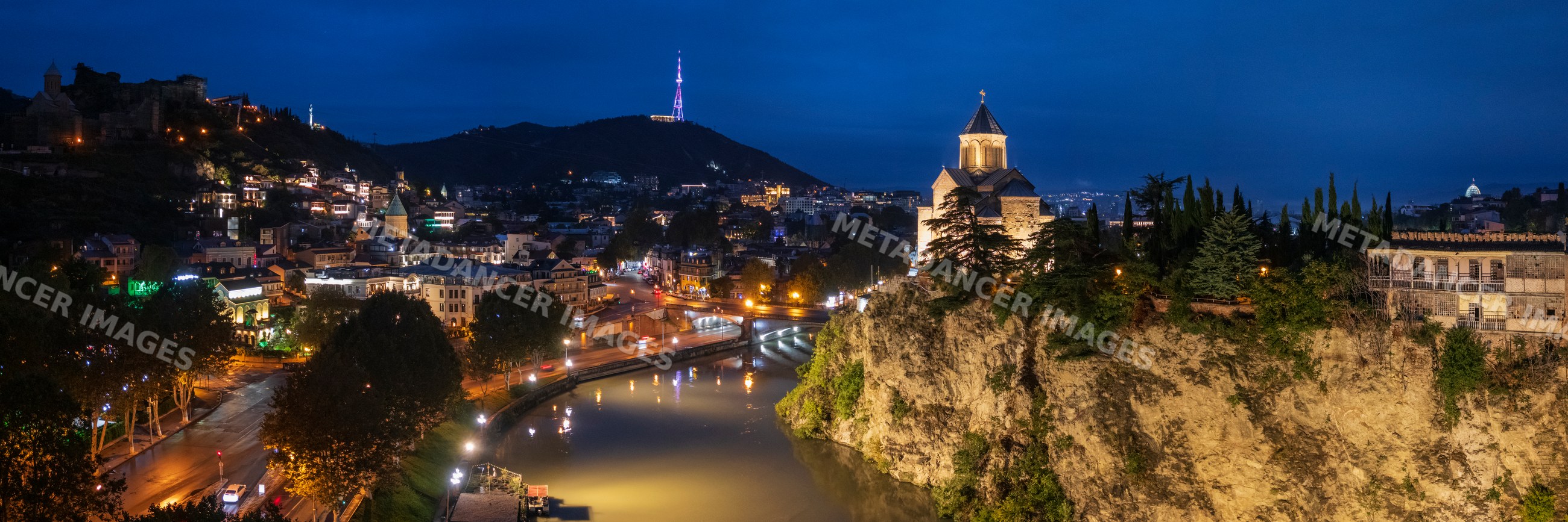 Metekhi Church illuminated on cliff over mtkwari river