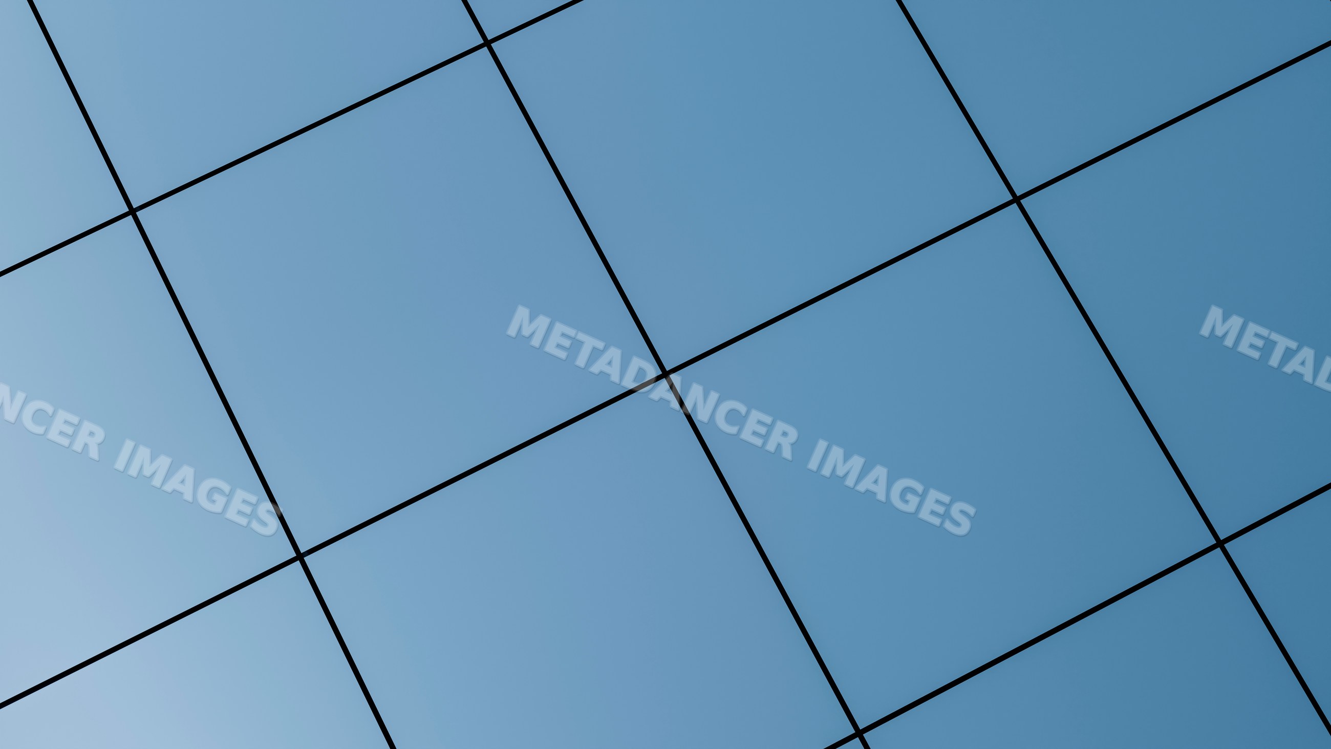 Modern building facade with blue glass panels reflecting the sky