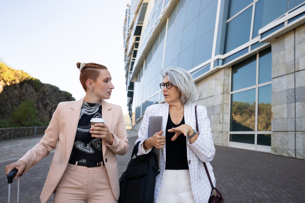 Businesswomen walking and talking outside modern office building