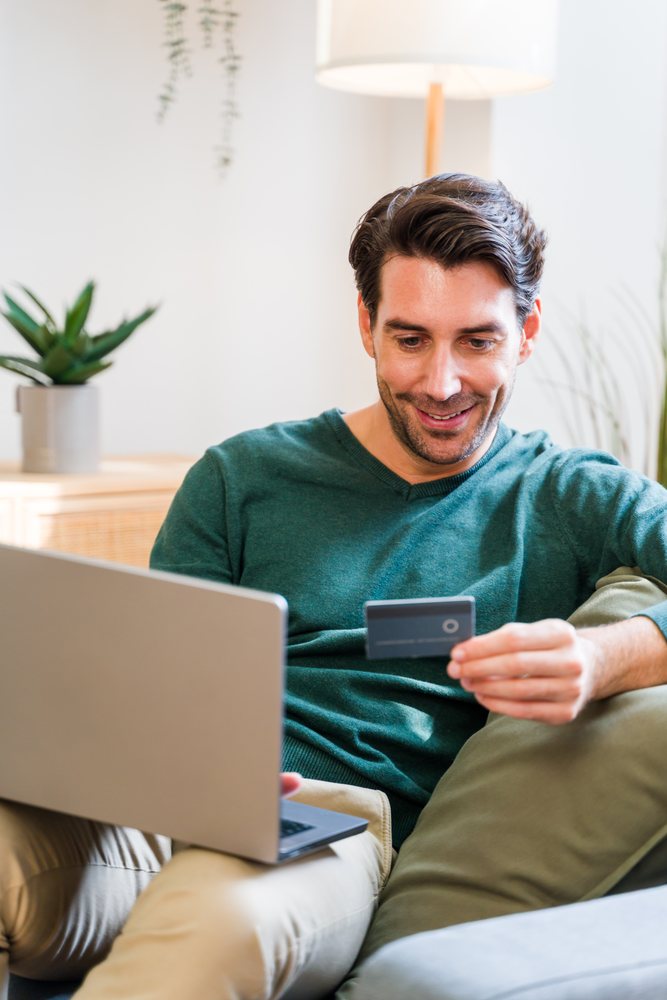 White man using laptop and credit card for online shopping