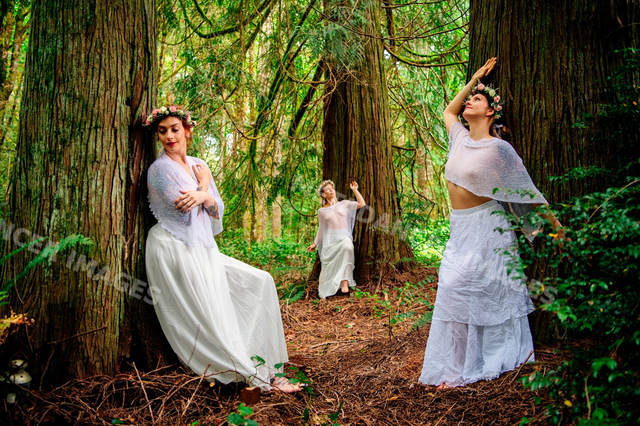 White women posing gracefully in a green forest with floral crowns