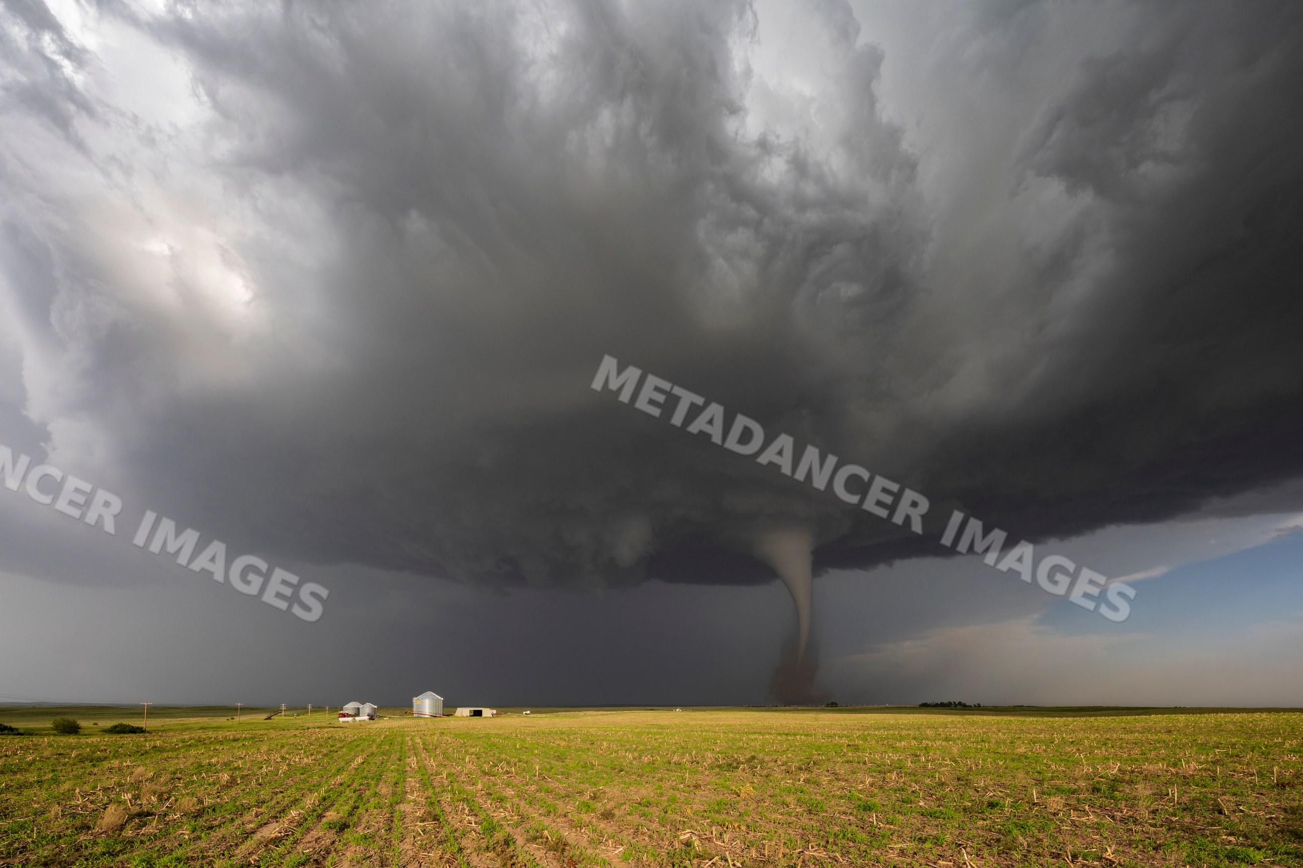Tornado forming beneath supercell storm over rural nebraska field