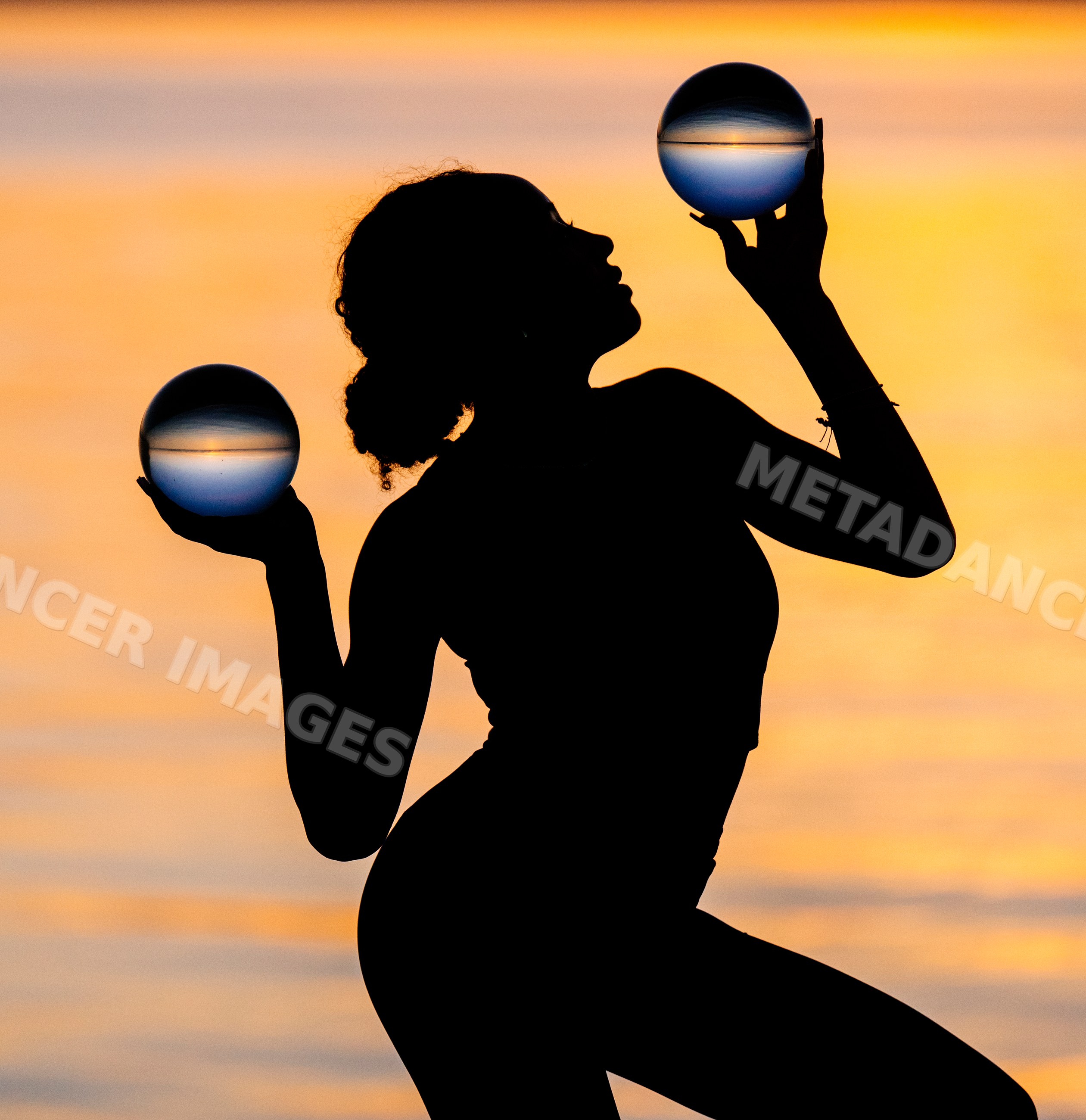 Silhouette of Hispanic woman holding glass balls