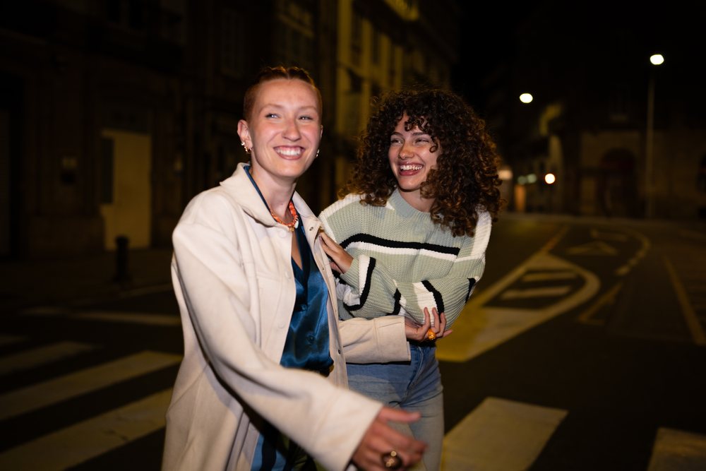 Two white women laughing during night walk on a Santiago De Compostela