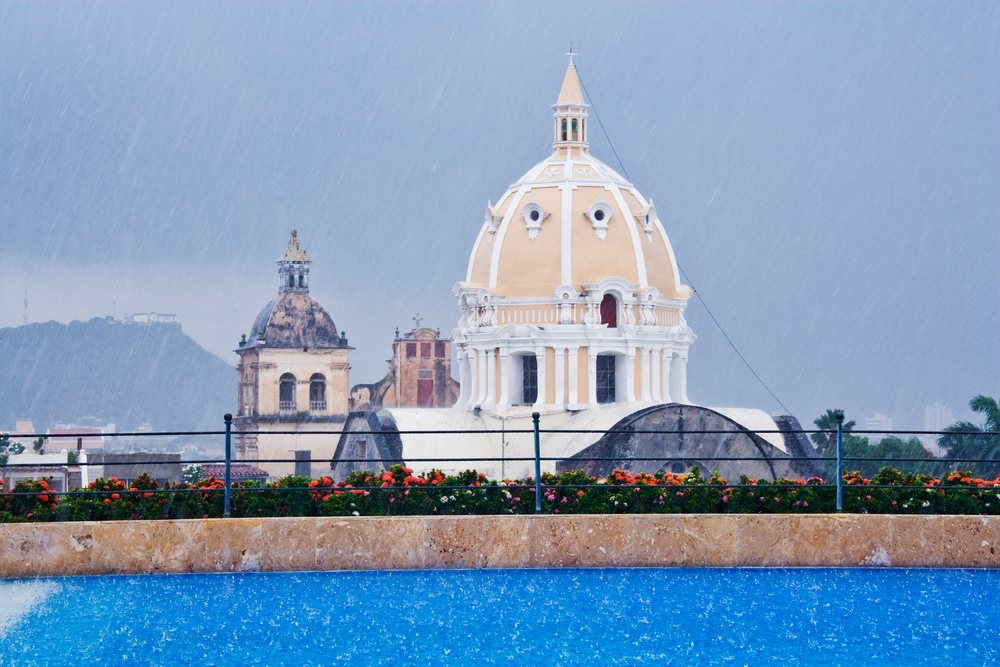 Church domes and rooftop swimming pool in rainy cartagena, colombia