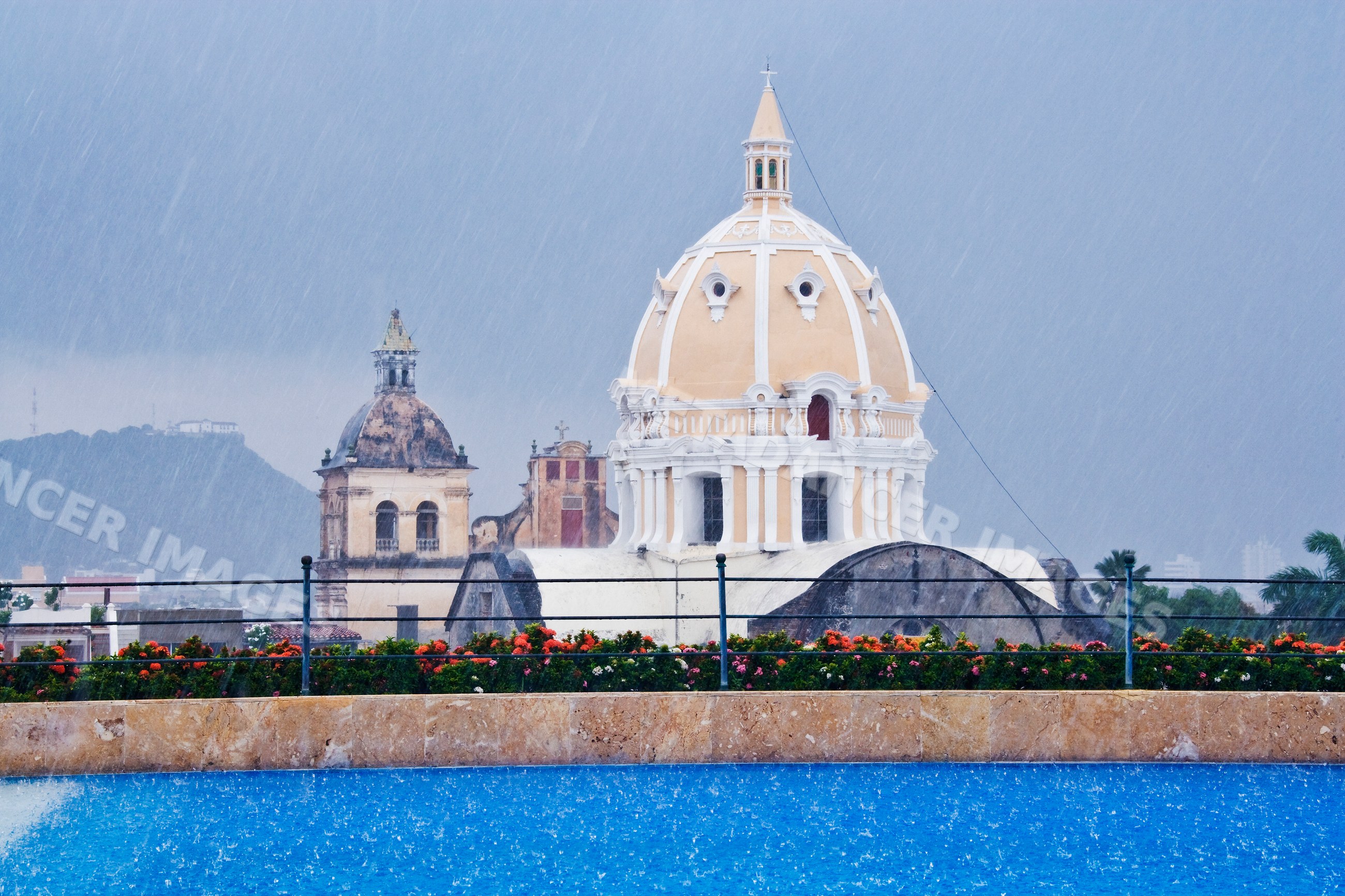 Church domes and rooftop swimming pool in rainy cartagena, colombia