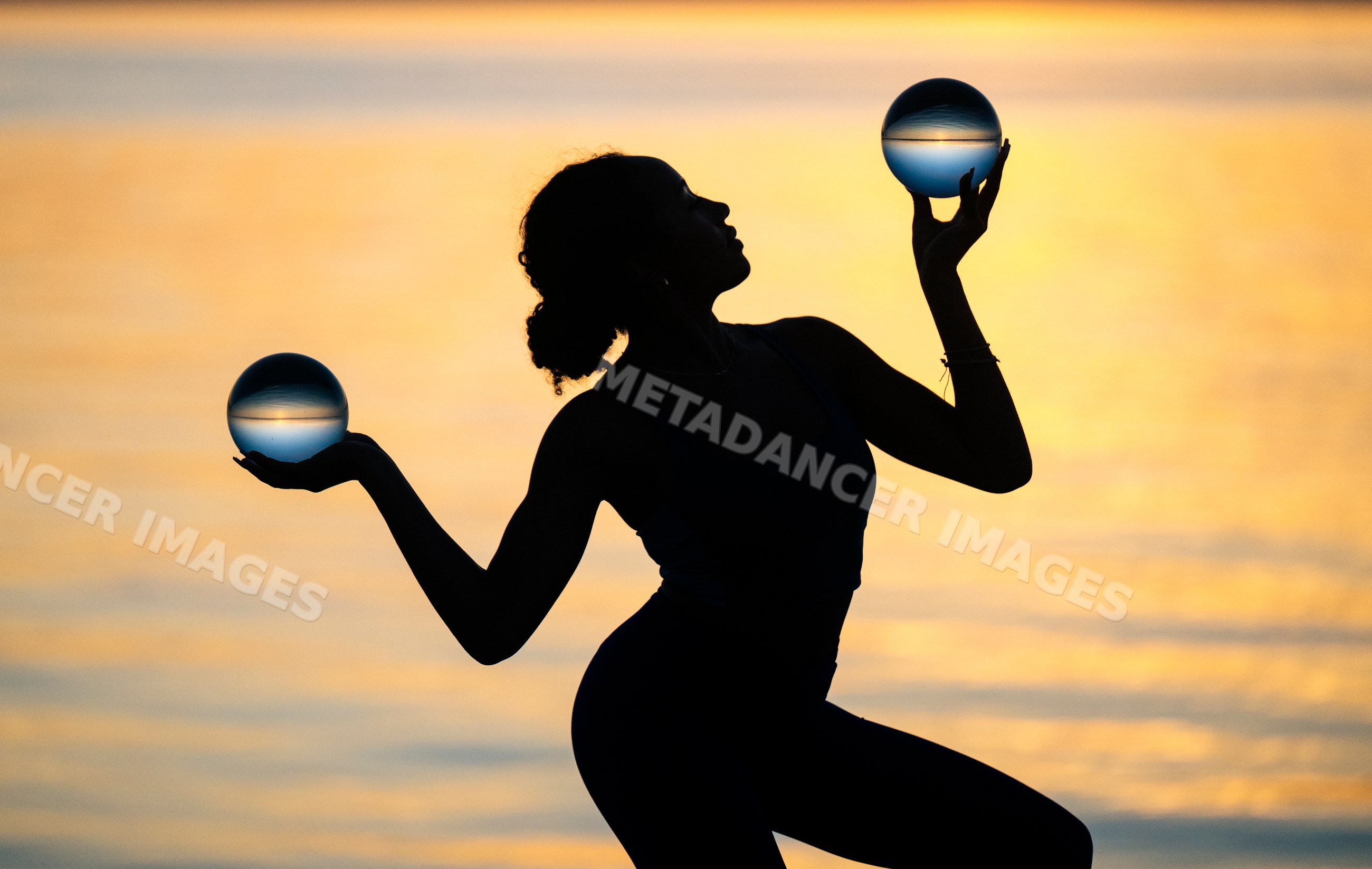 Hispanic woman balancing two crystal balls