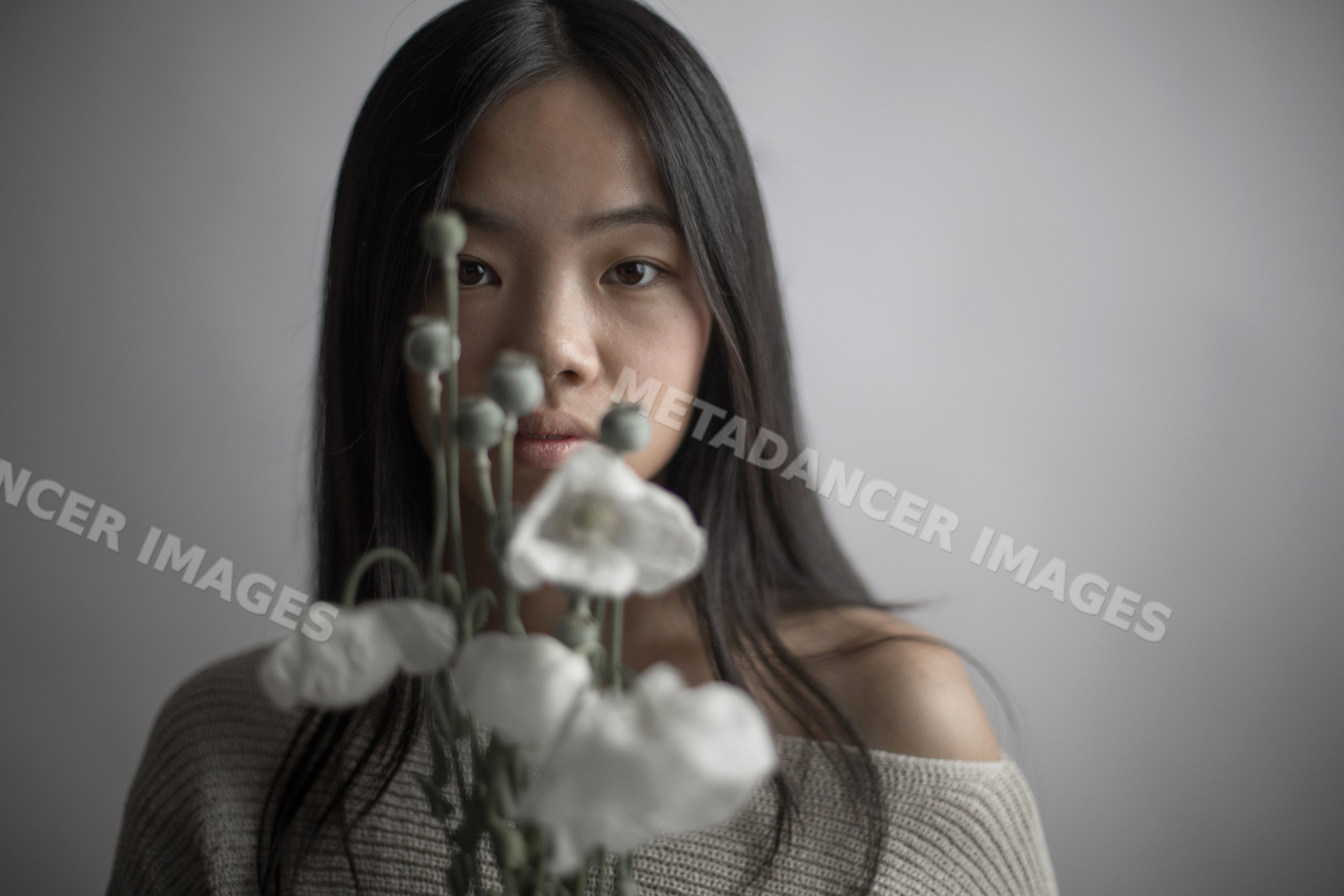 Portrait of a Southeast Asian woman holding white flowers