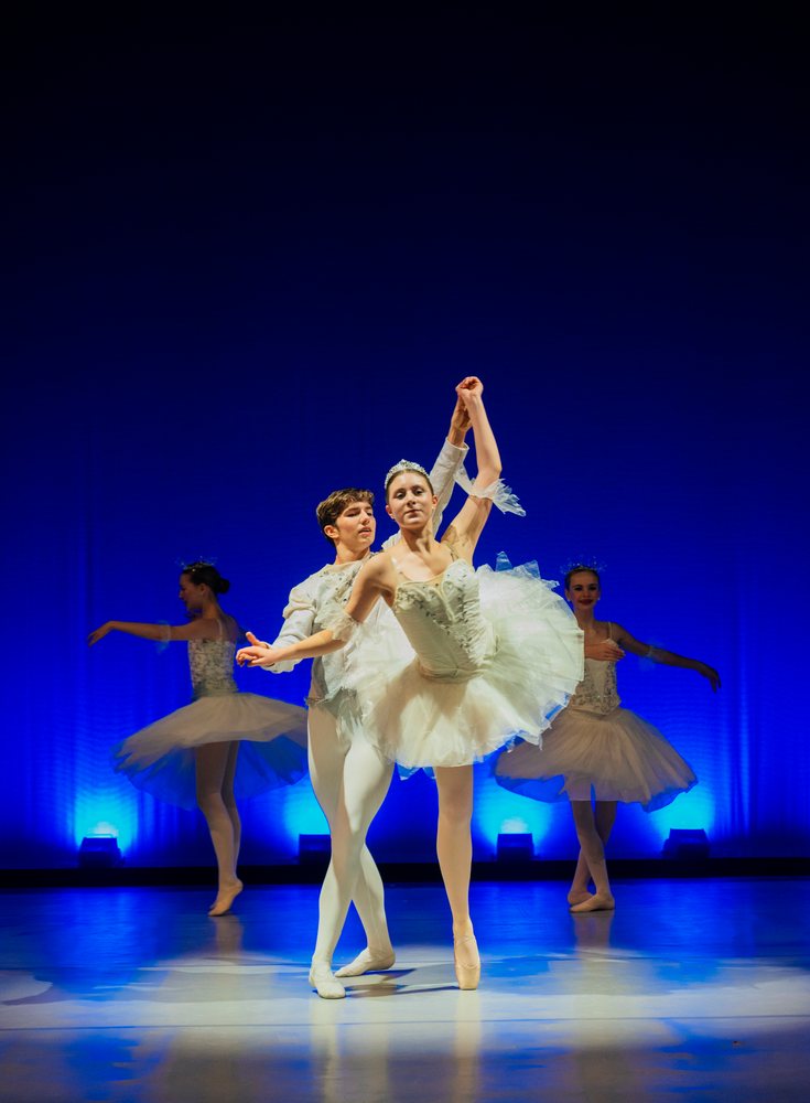 Male and female ballet dancers performing a pas de deux on stage