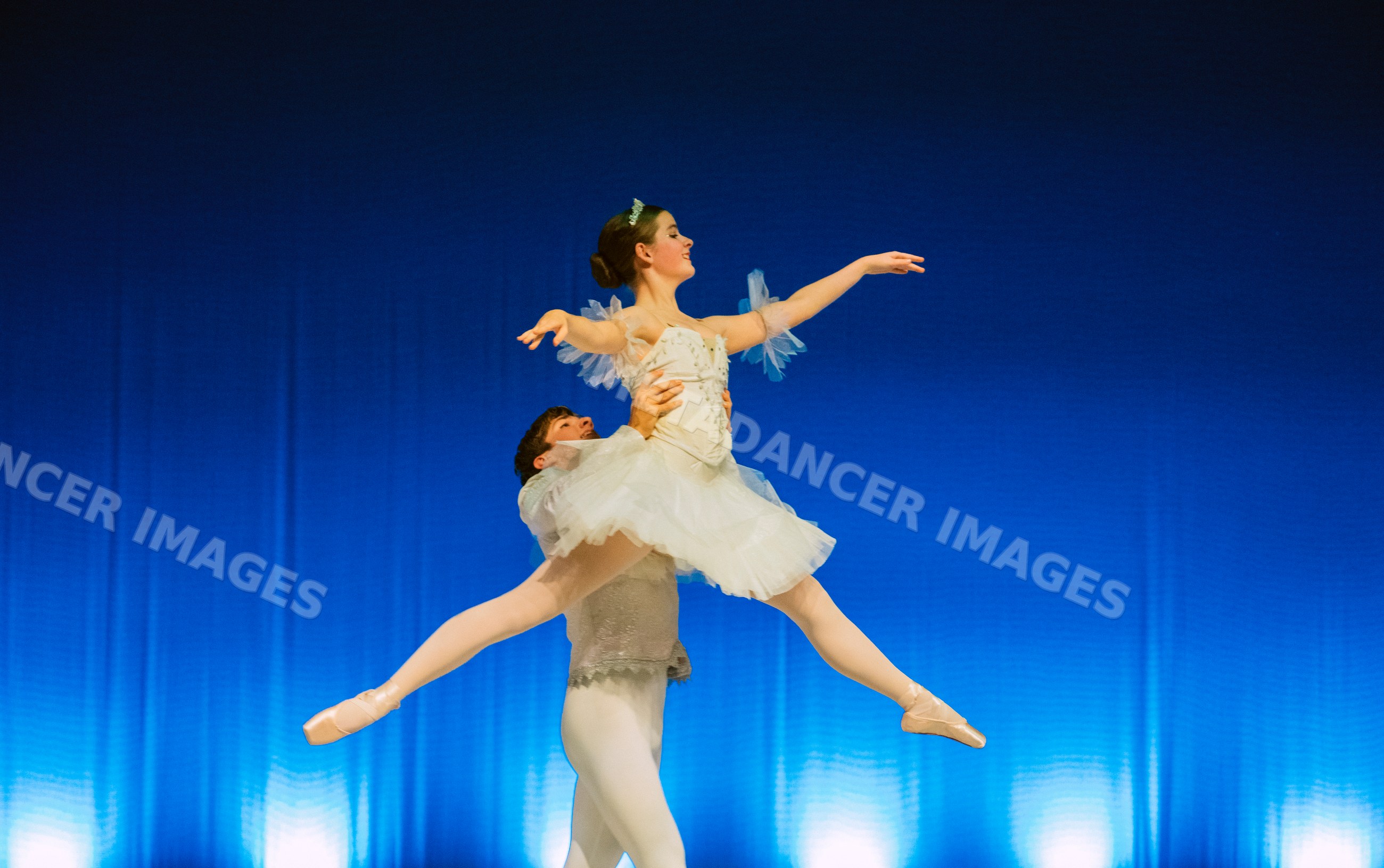 Ballet dancers perform a graceful lift during a stage performance
