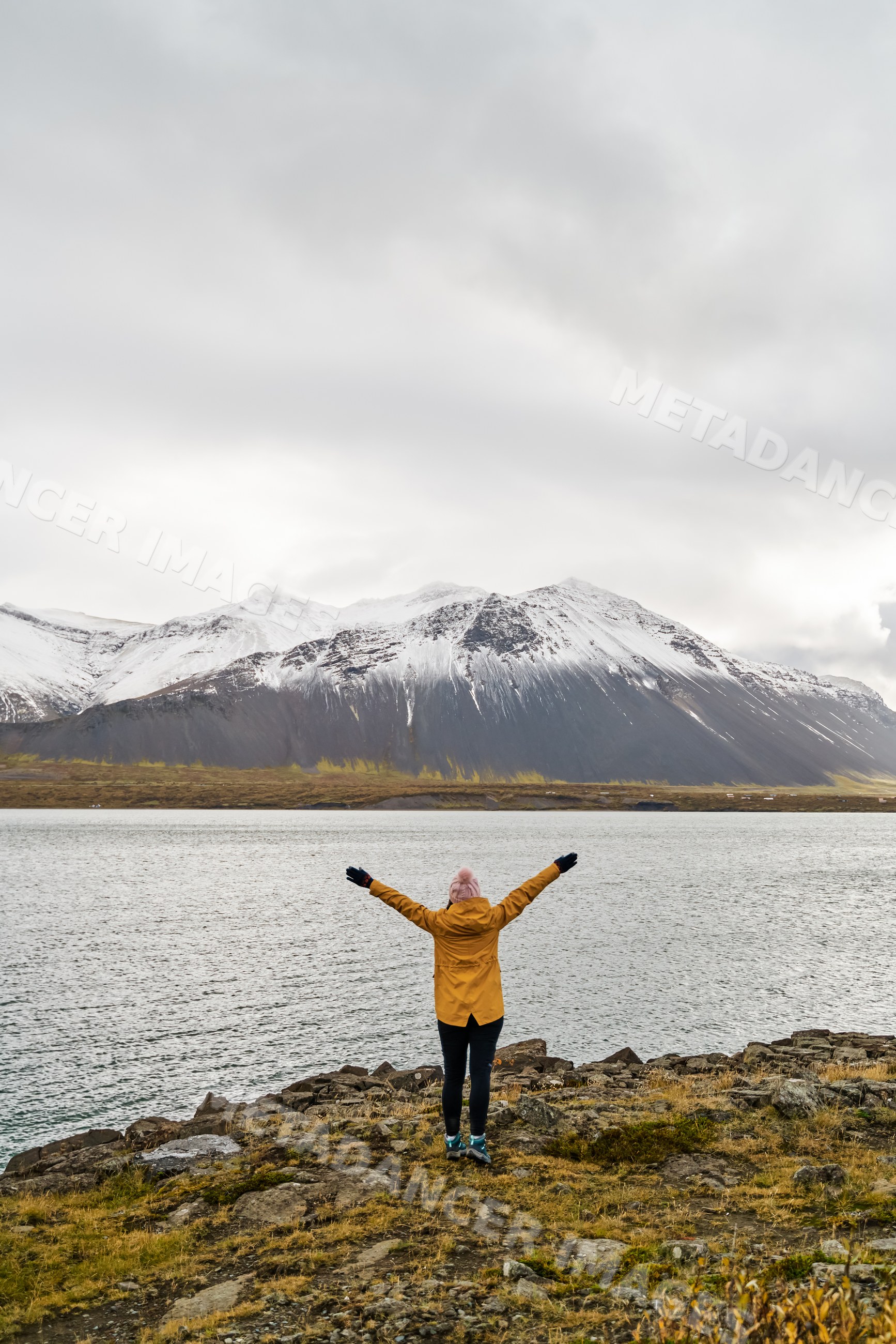 A white person enjoys the scenic view of snow-covered mountains