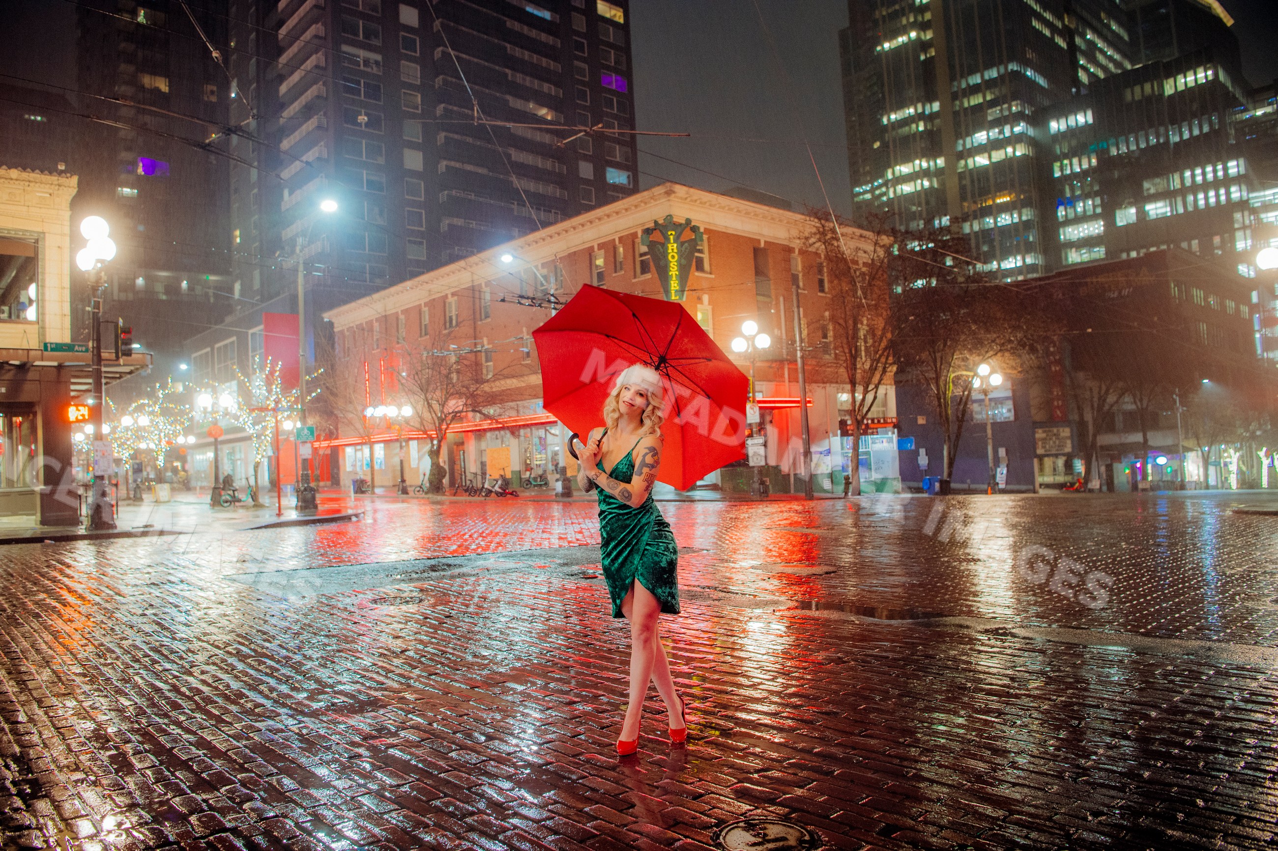 White woman with red umbrella on rainy night in Seattle urban street