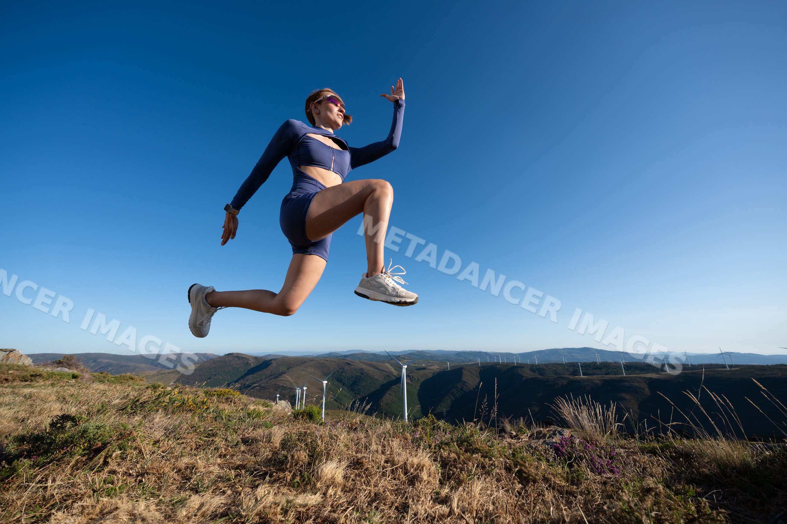 White Woman in athletic wear jumping outdoors in the hills of Galicia