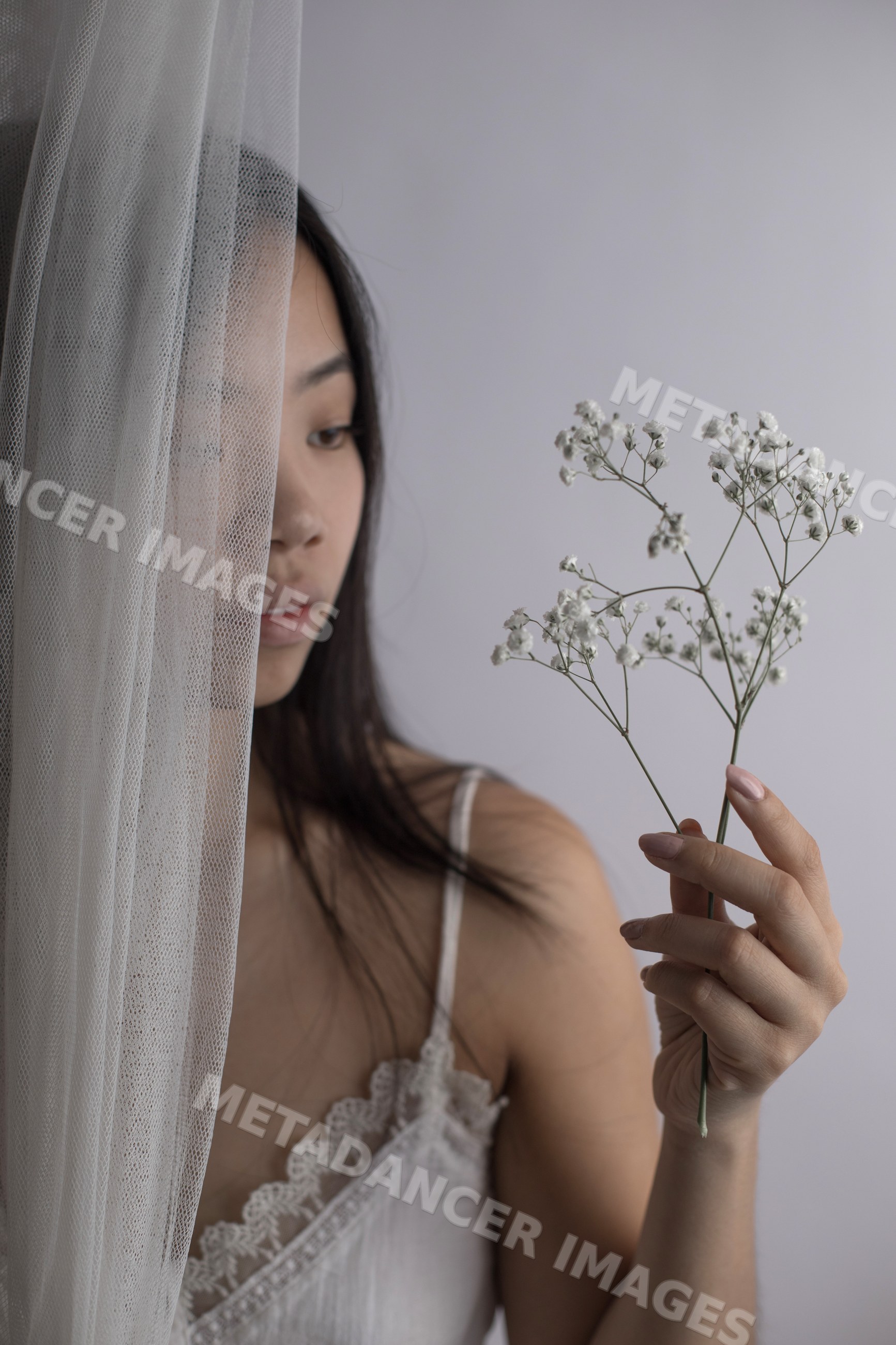 Southeast Asian woman holding delicate baby's breath flowers