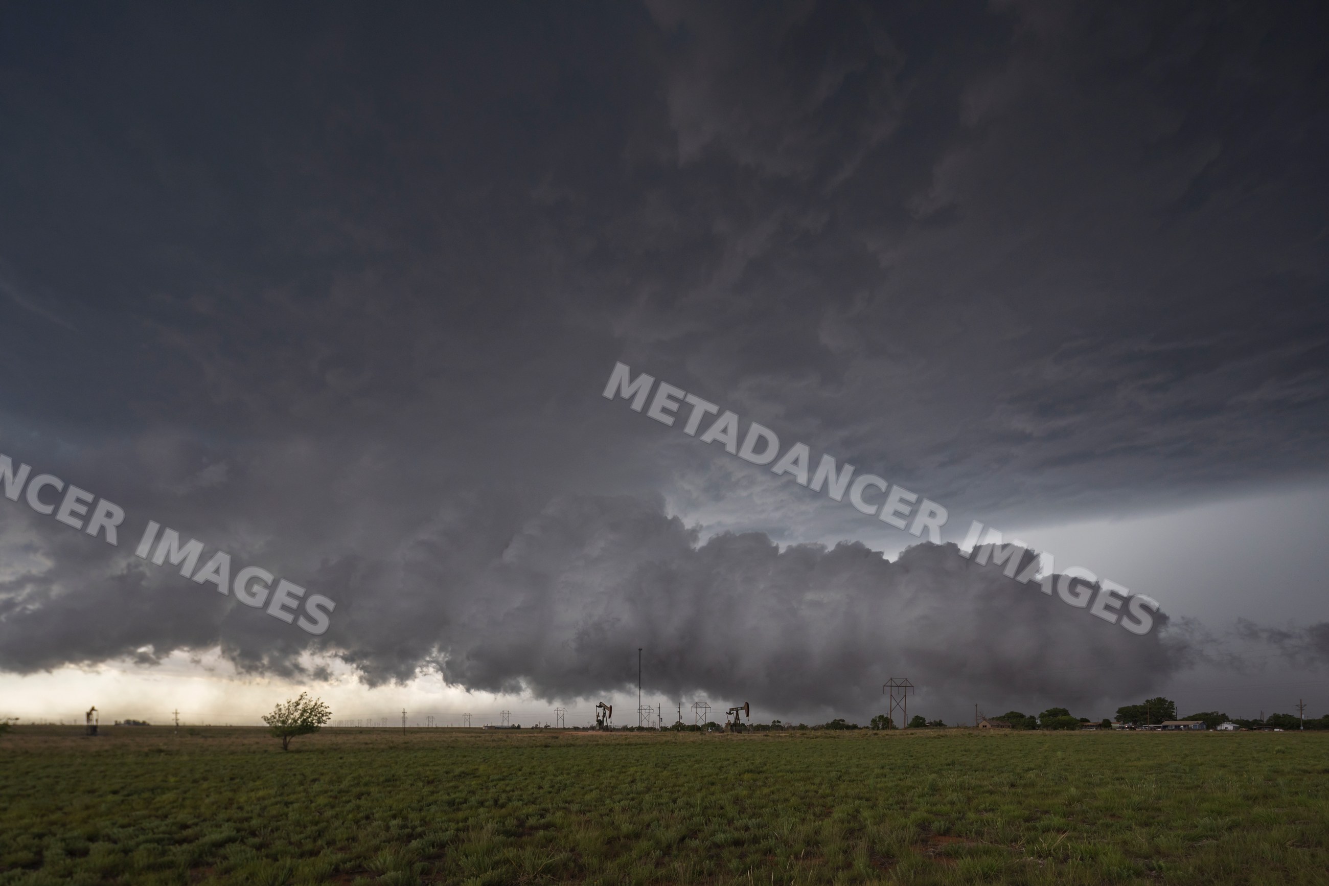 Storm cloud over grassy field with oil pumps in levelland texas
