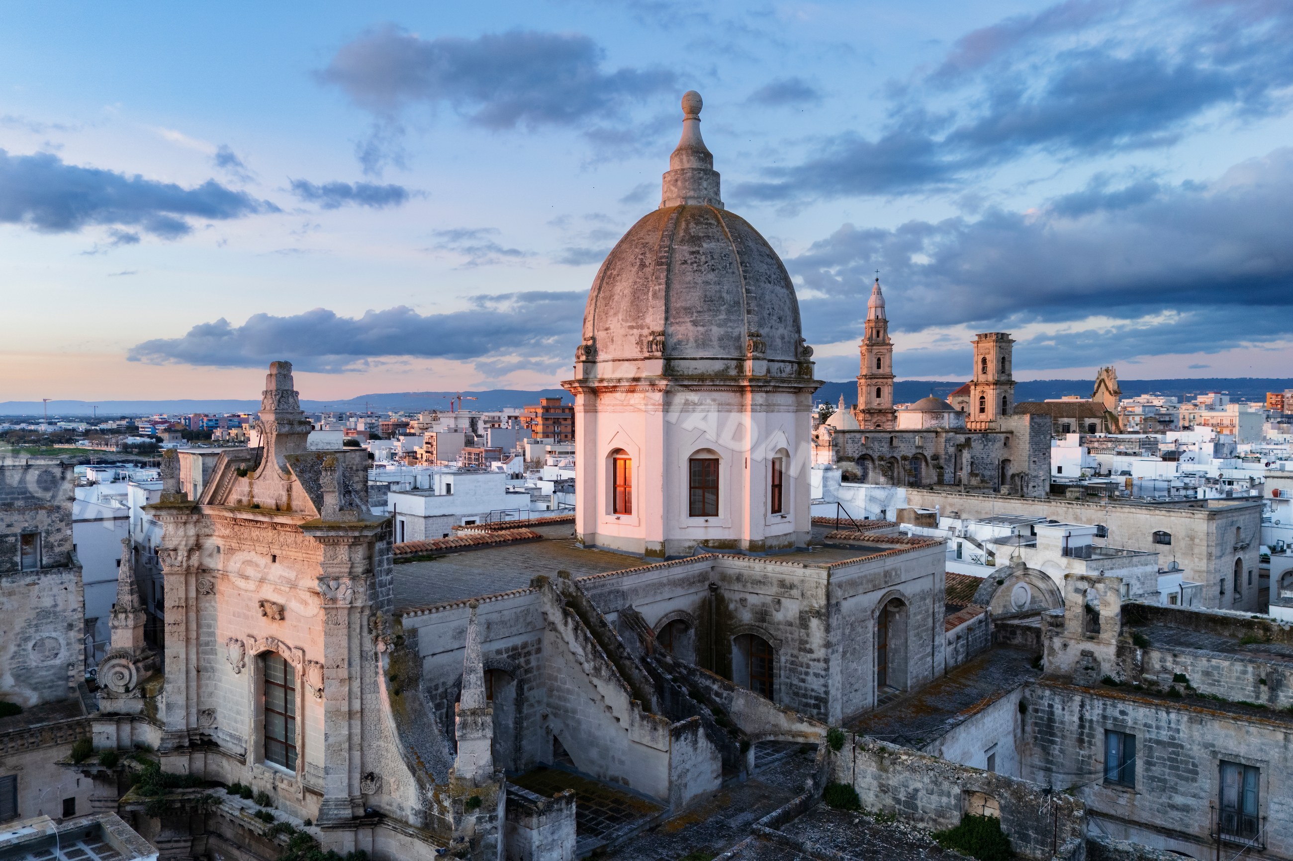 Historic cathedral dome and rooftops at Sunrise in monopoli, Italy