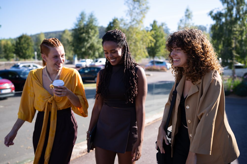Three diverse African American and white women walking and laughing