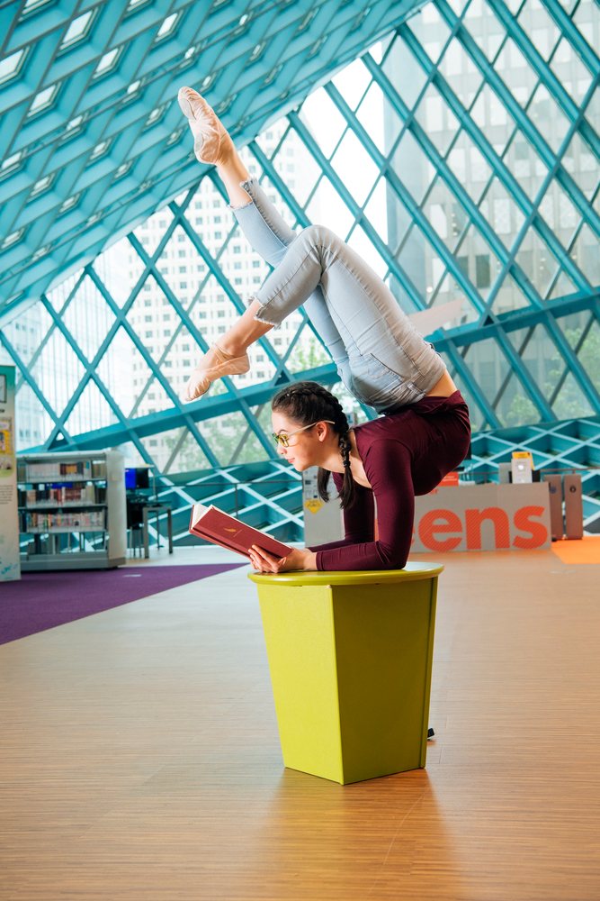 A woman balances in a contortionist pose while reading in a Seattle