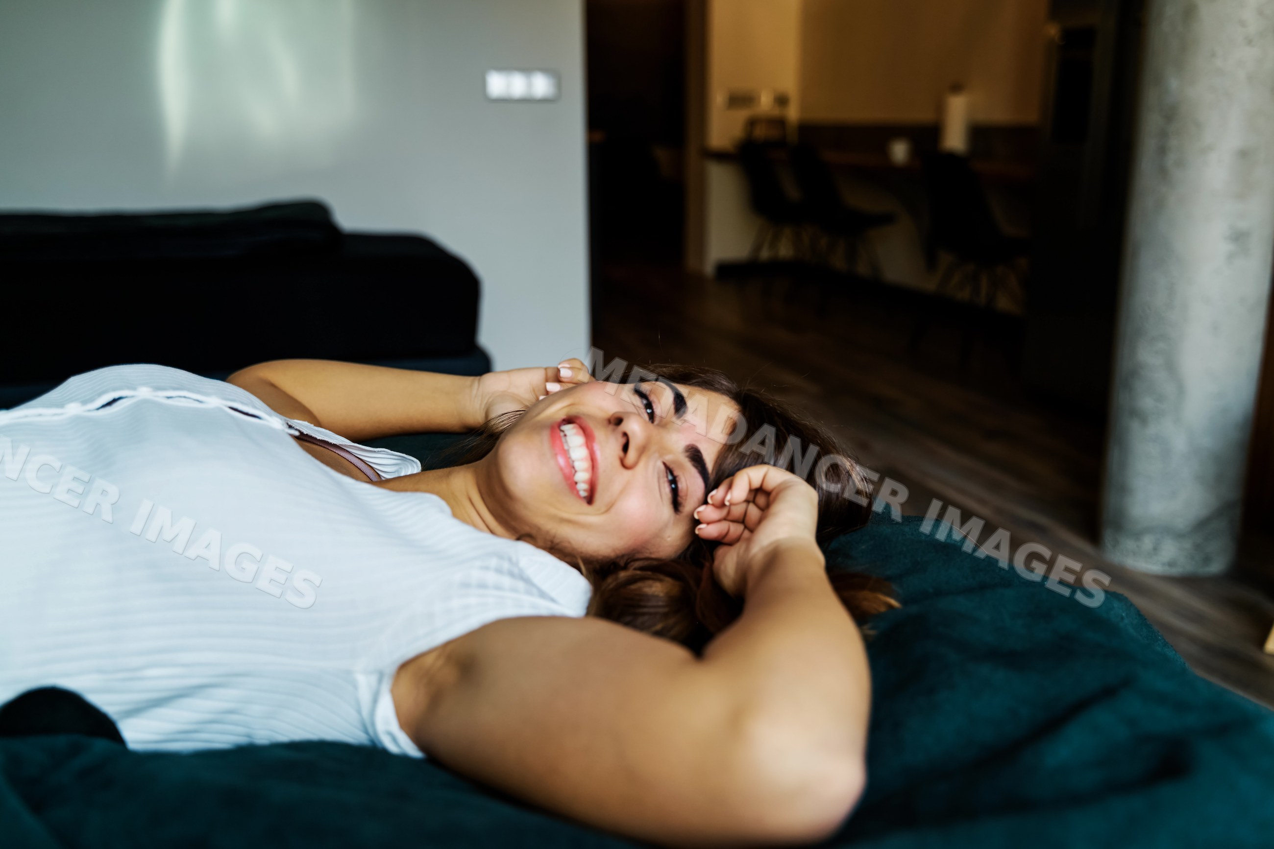 A woman is relaxing and smiling on a couch