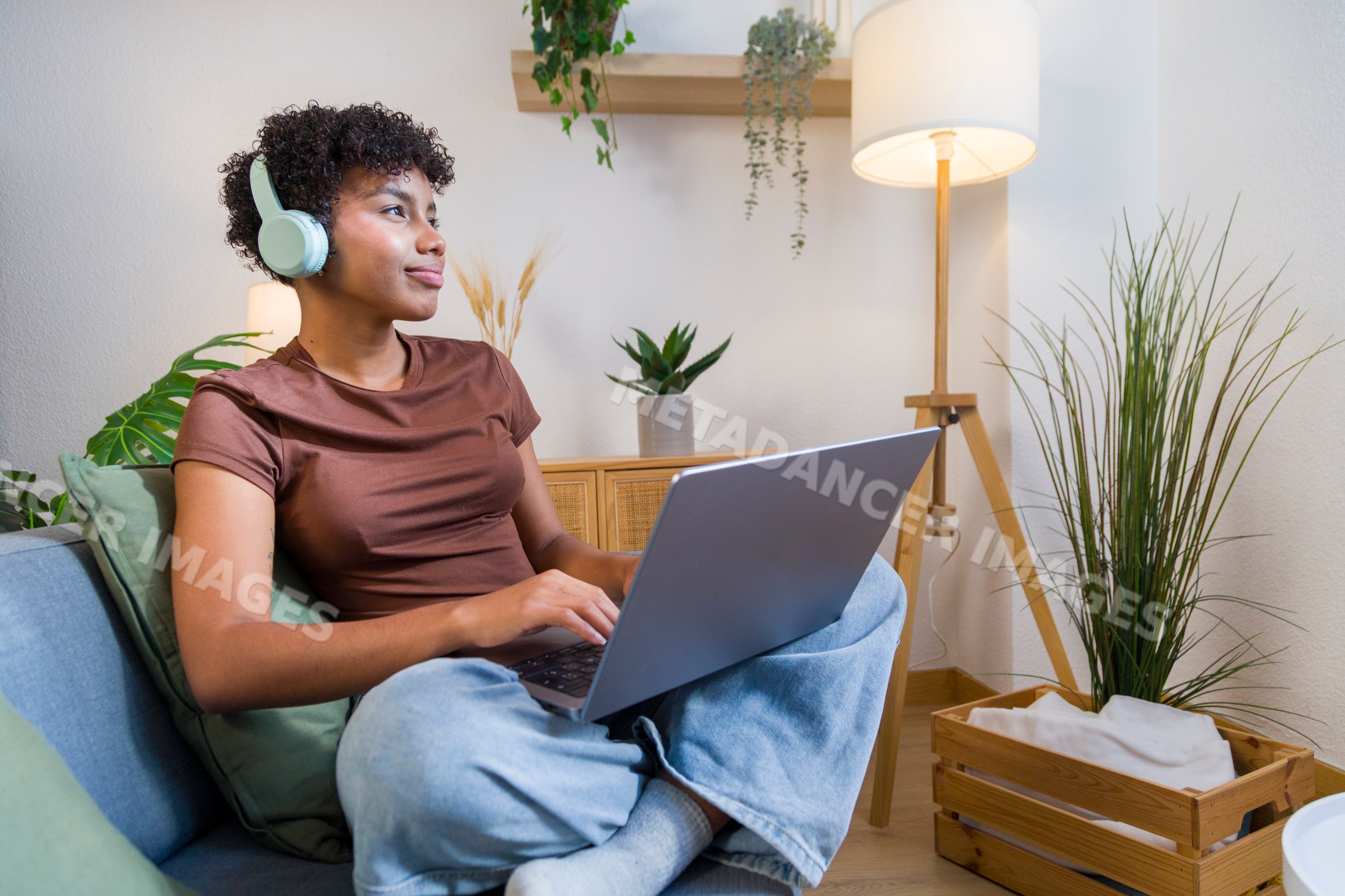 Young African American woman using laptop with headphones