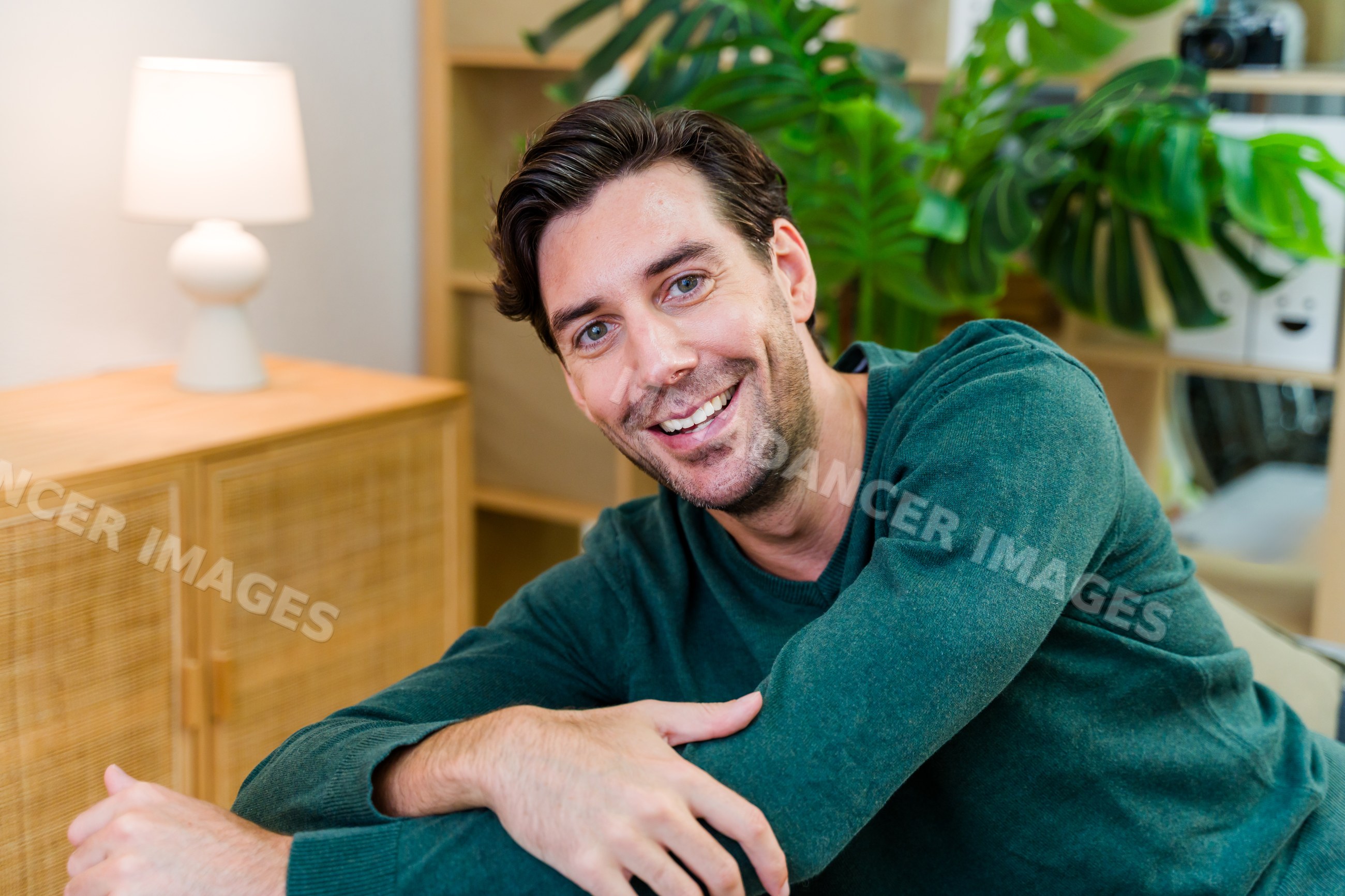 White man smiling relaxed indoors in home living room setting