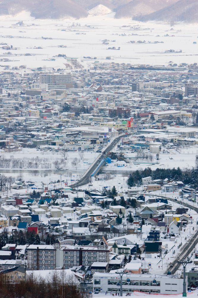 Snow-covered furano town with bridge and ski lifts japan