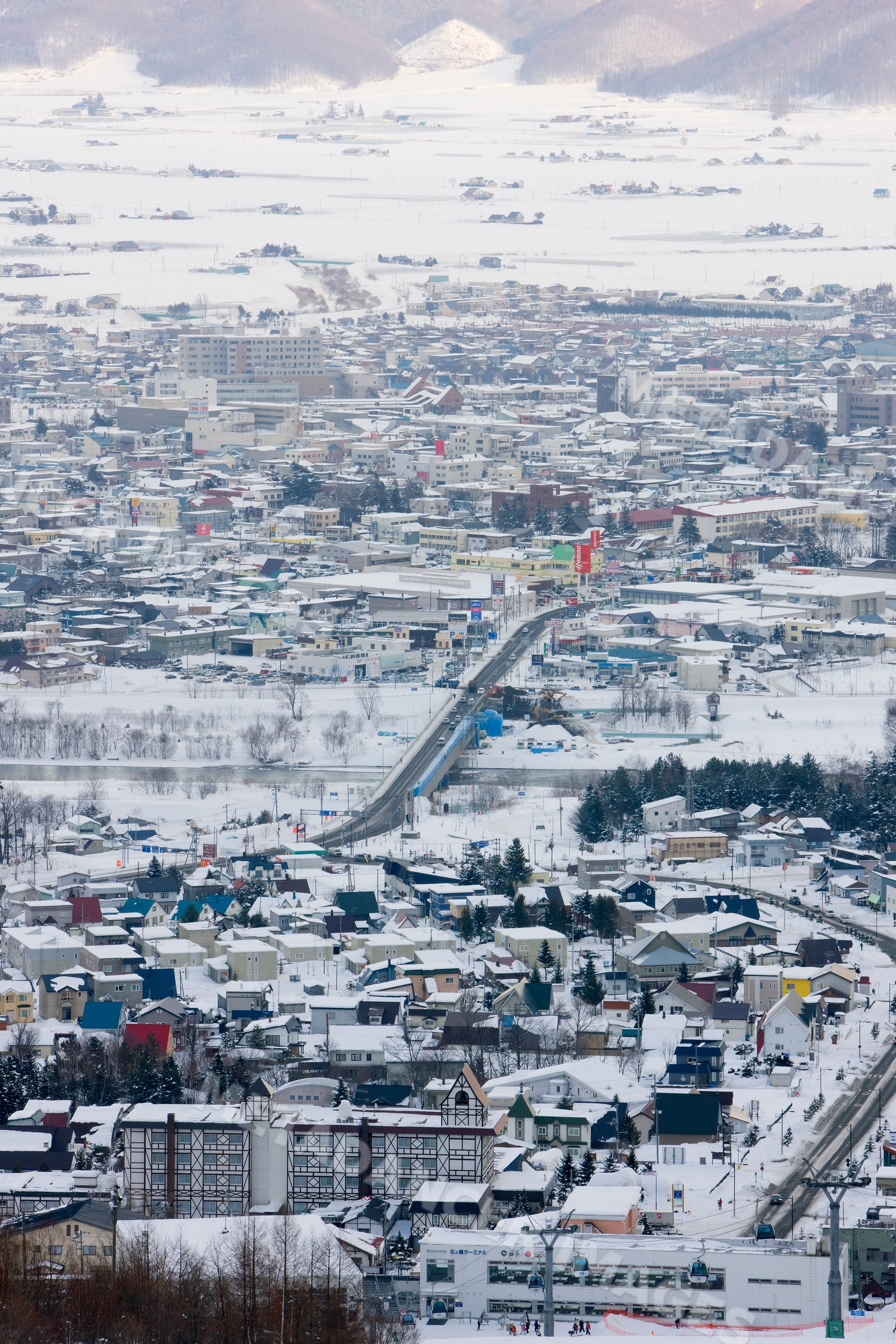 Snow-covered furano town with bridge and ski lifts japan