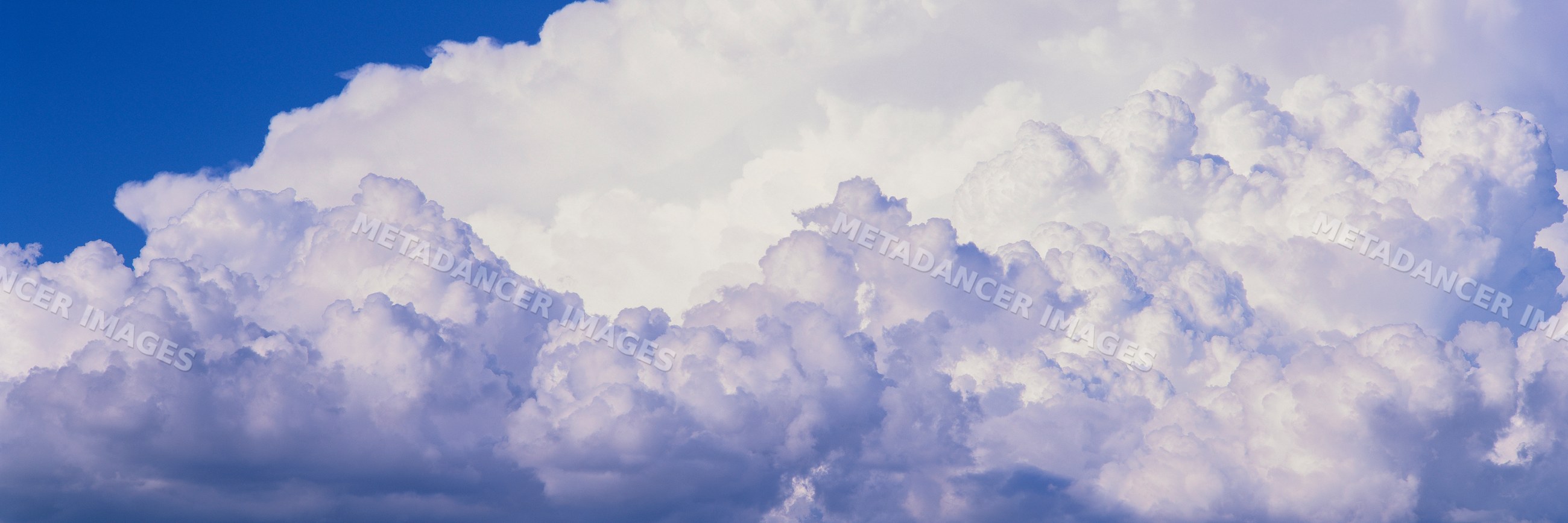 White cumulus clouds in vibrant blue sky