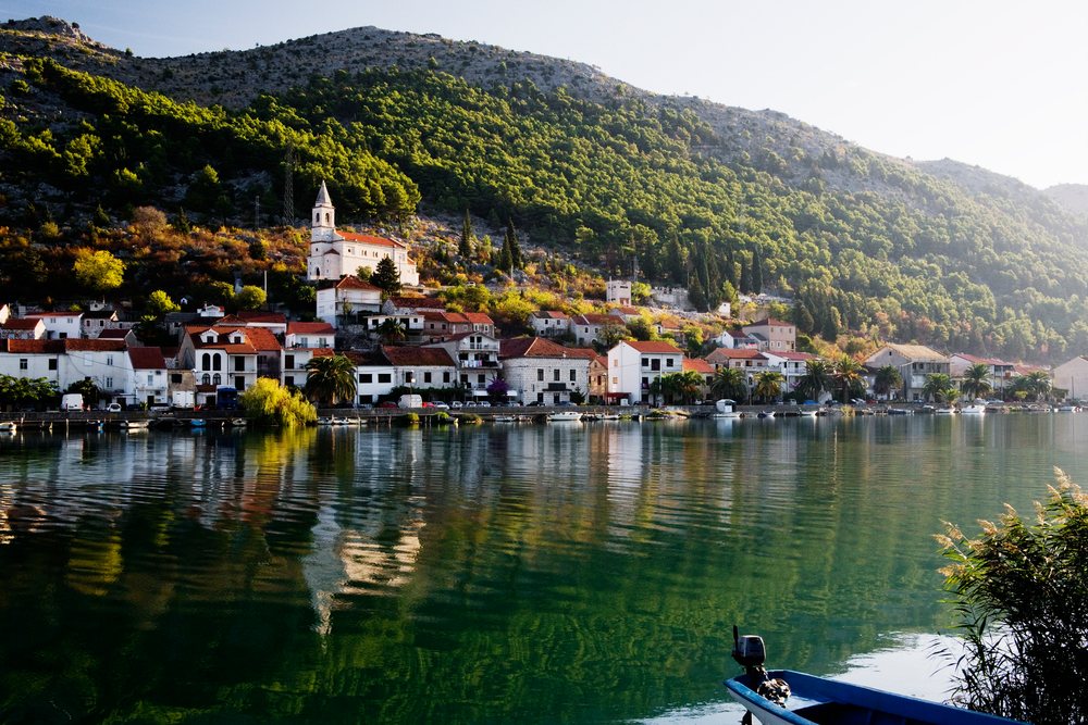 Komin village waterfront with church and boats
