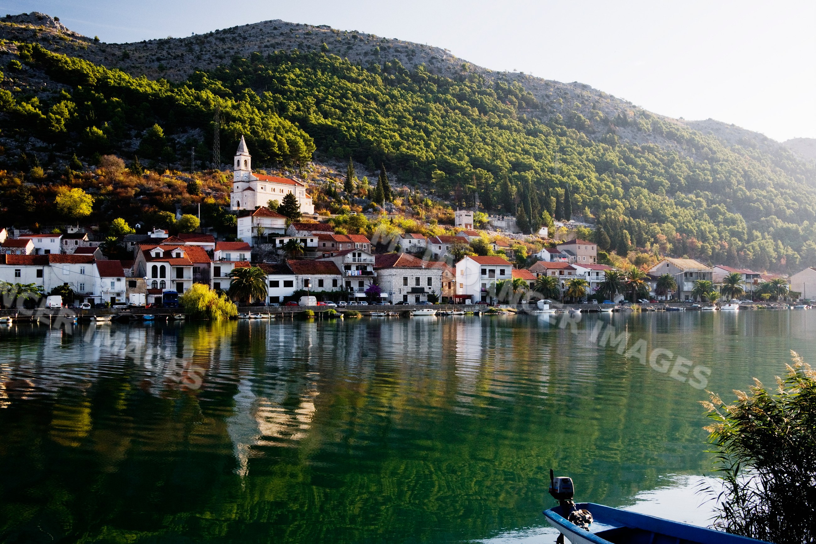 Komin village waterfront with church and boats