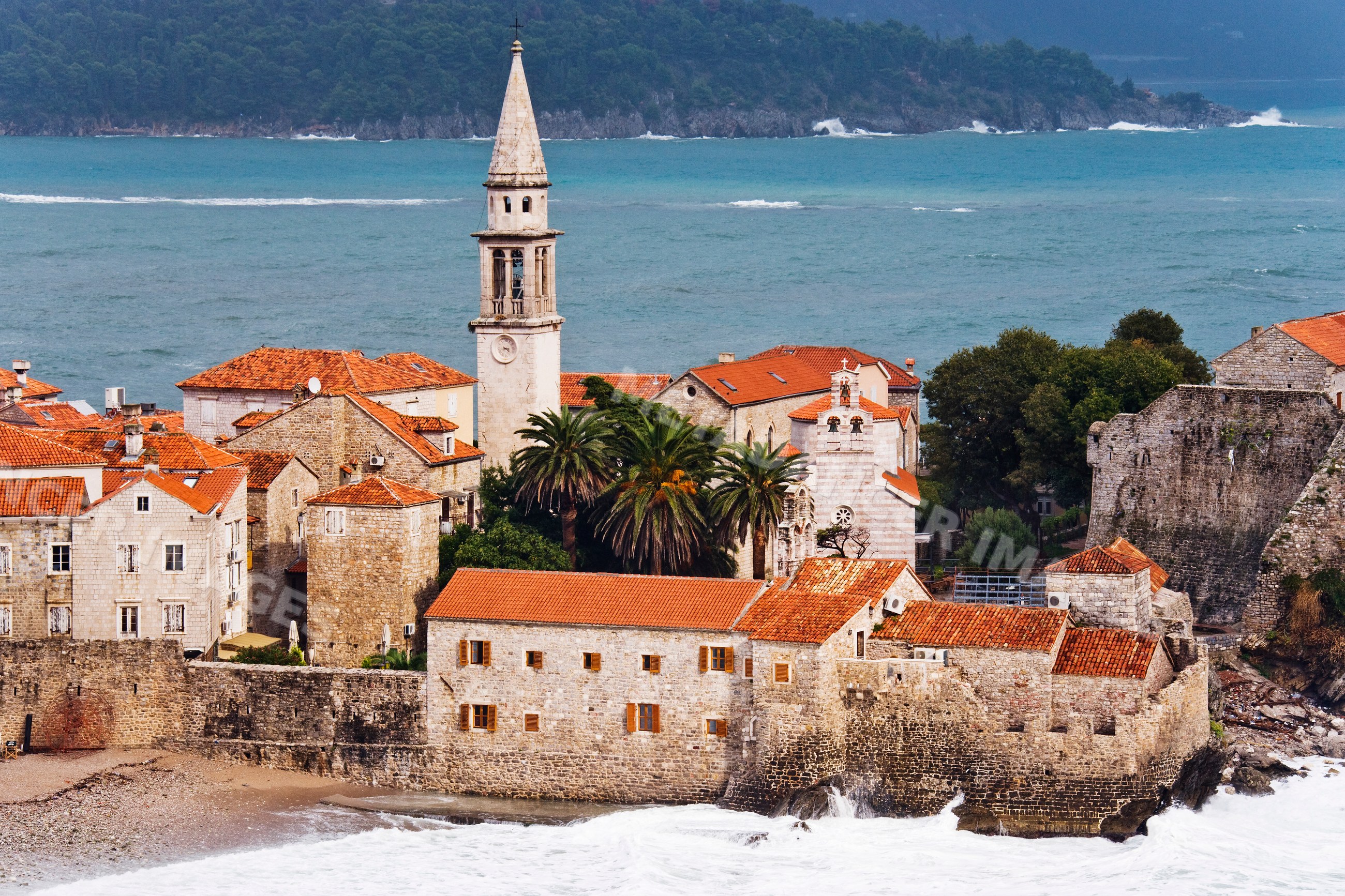 Old town fortress with red tile roofs and church tower, montenegro