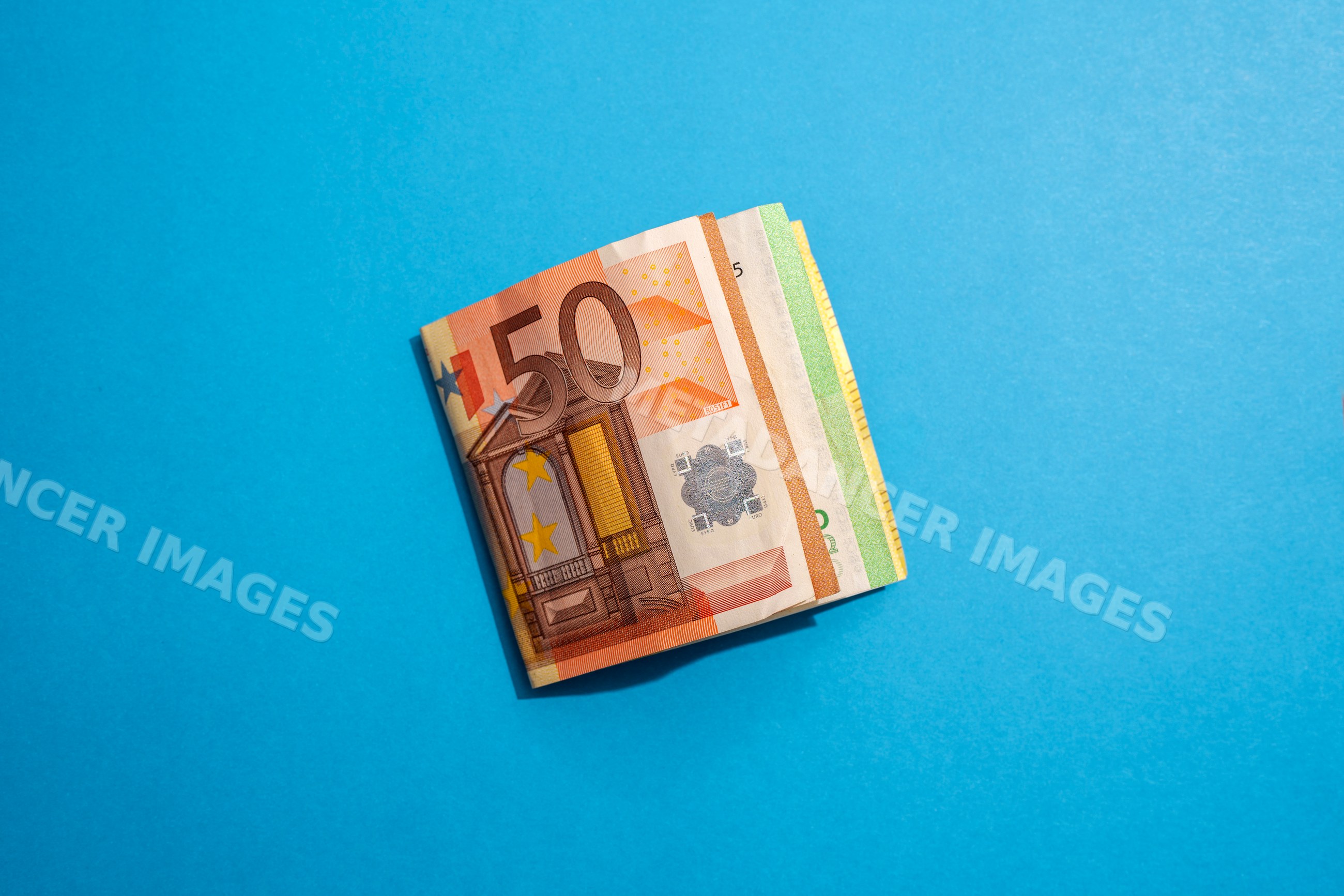 Stack of euro banknotes on blue background
