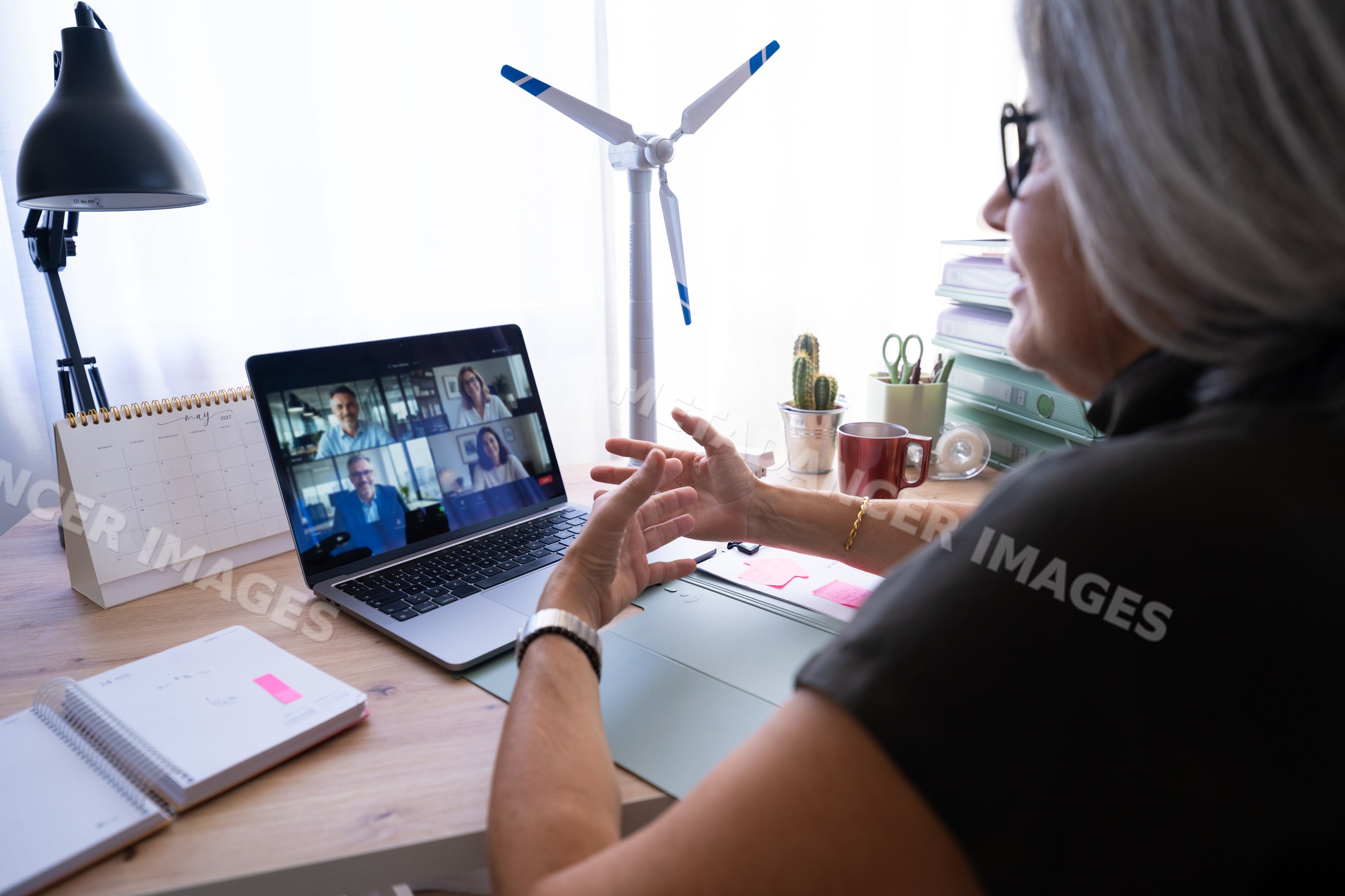 White woman participating in video call on laptop in home office