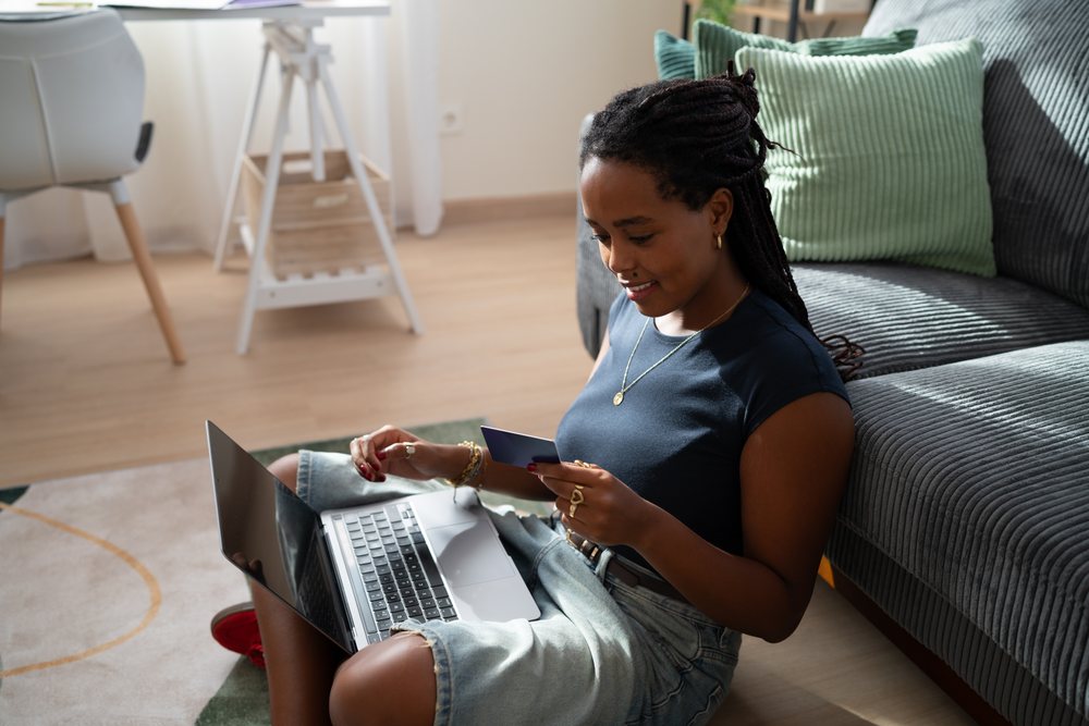 African American woman shops online with a credit card and laptop