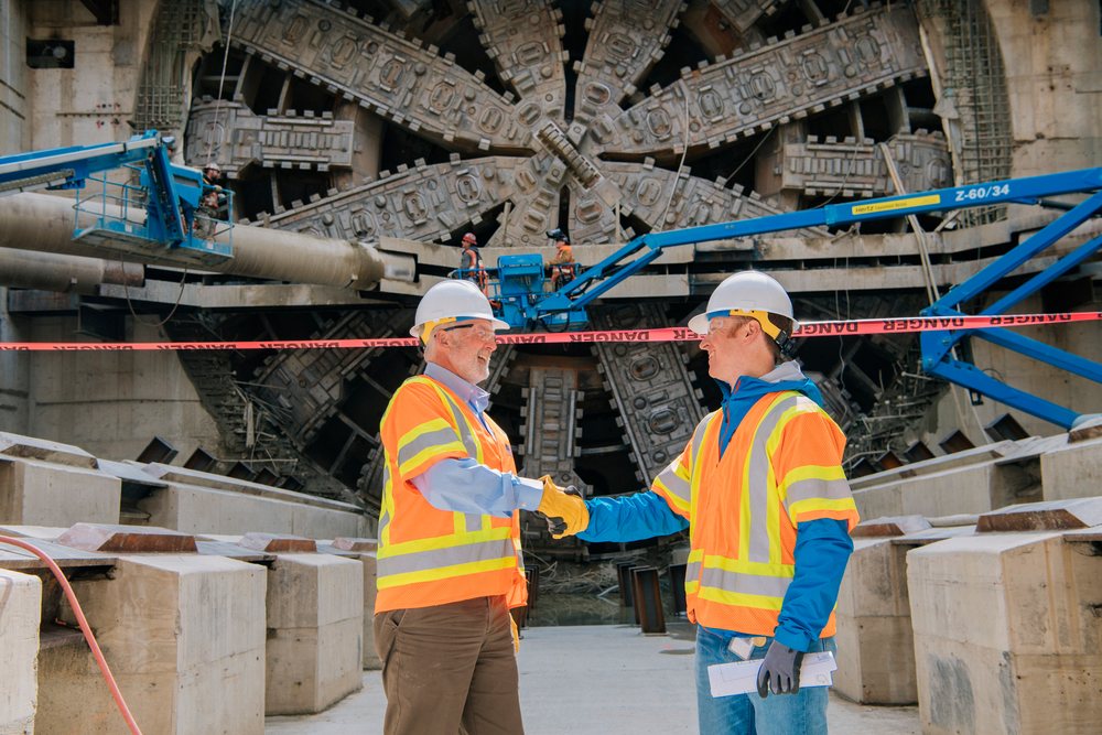 Two white construction workers shake hands
