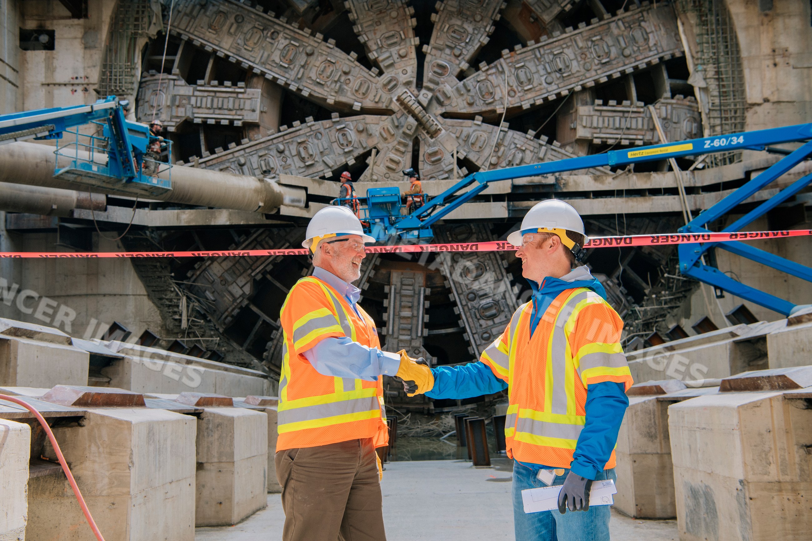 Two construction white workers shake hands