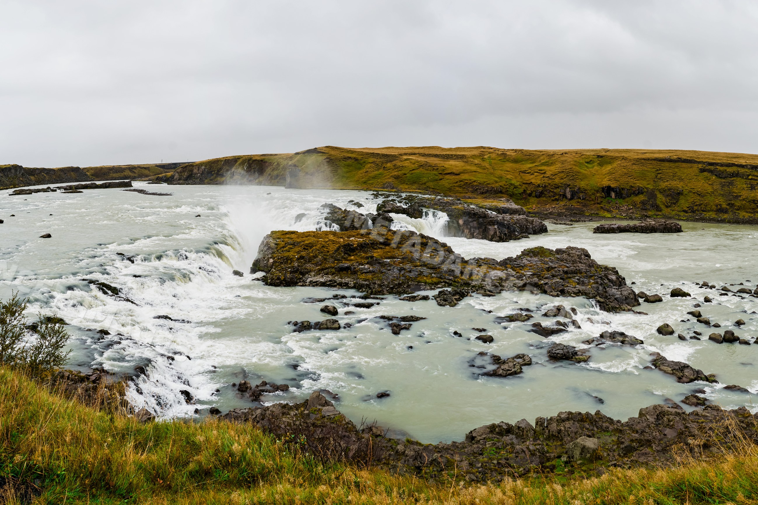 A panoramic view of a rocky river waterfall
