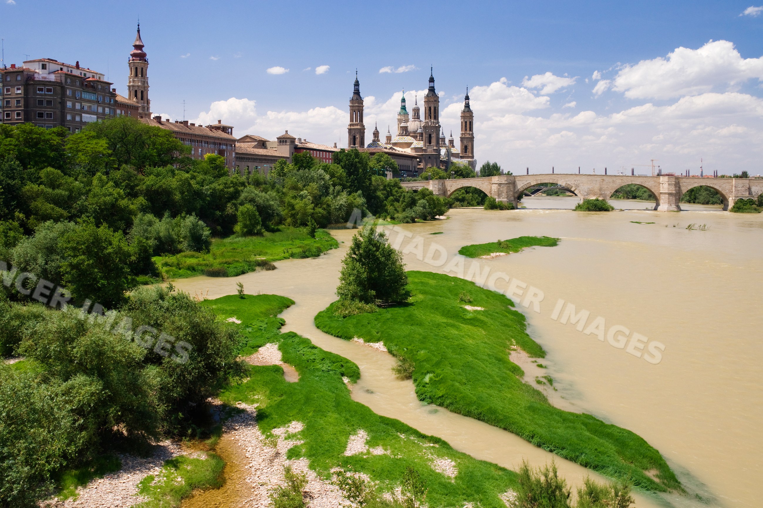 River with stone bridge and church towers in historic Cordoba town, Spain