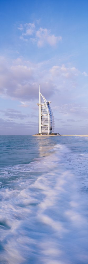 The burj al arab hotel stands on an artificial island amid sea waves