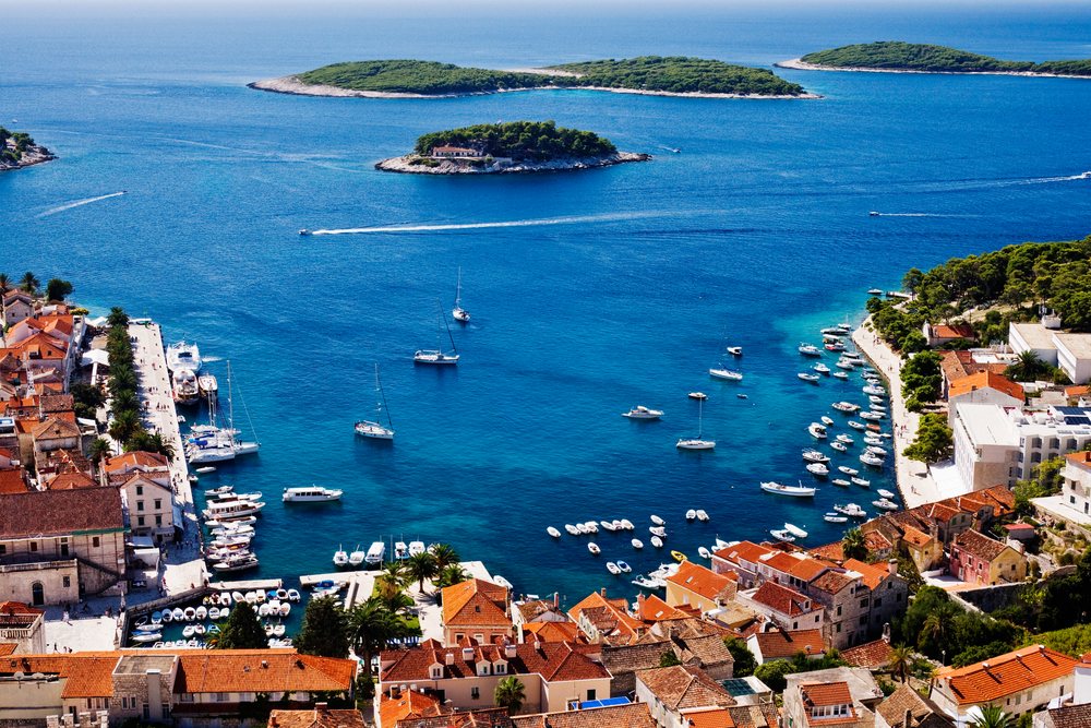 Town of hvar harbor with boats and islands