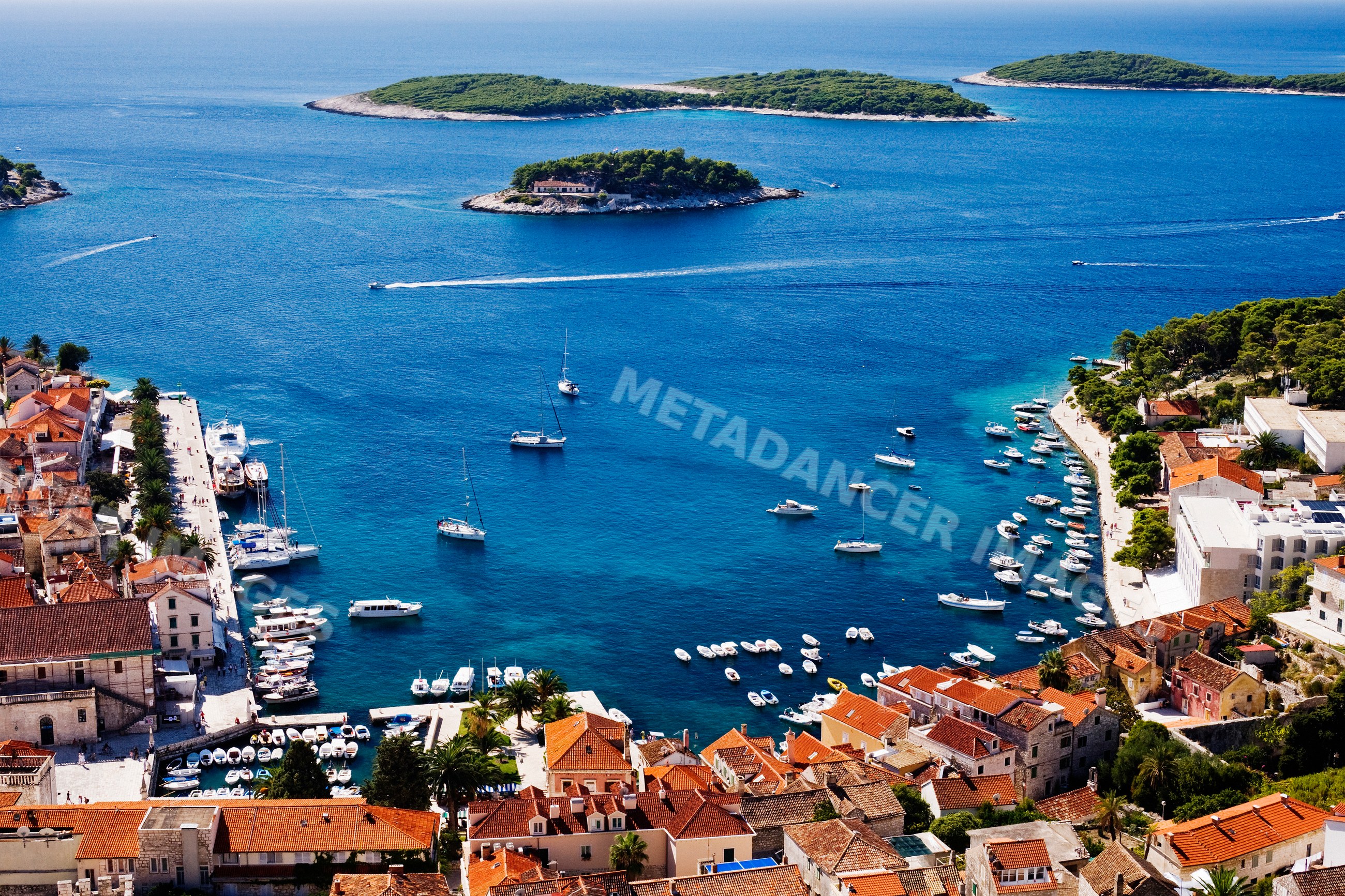 Town of hvar harbor with boats and islands