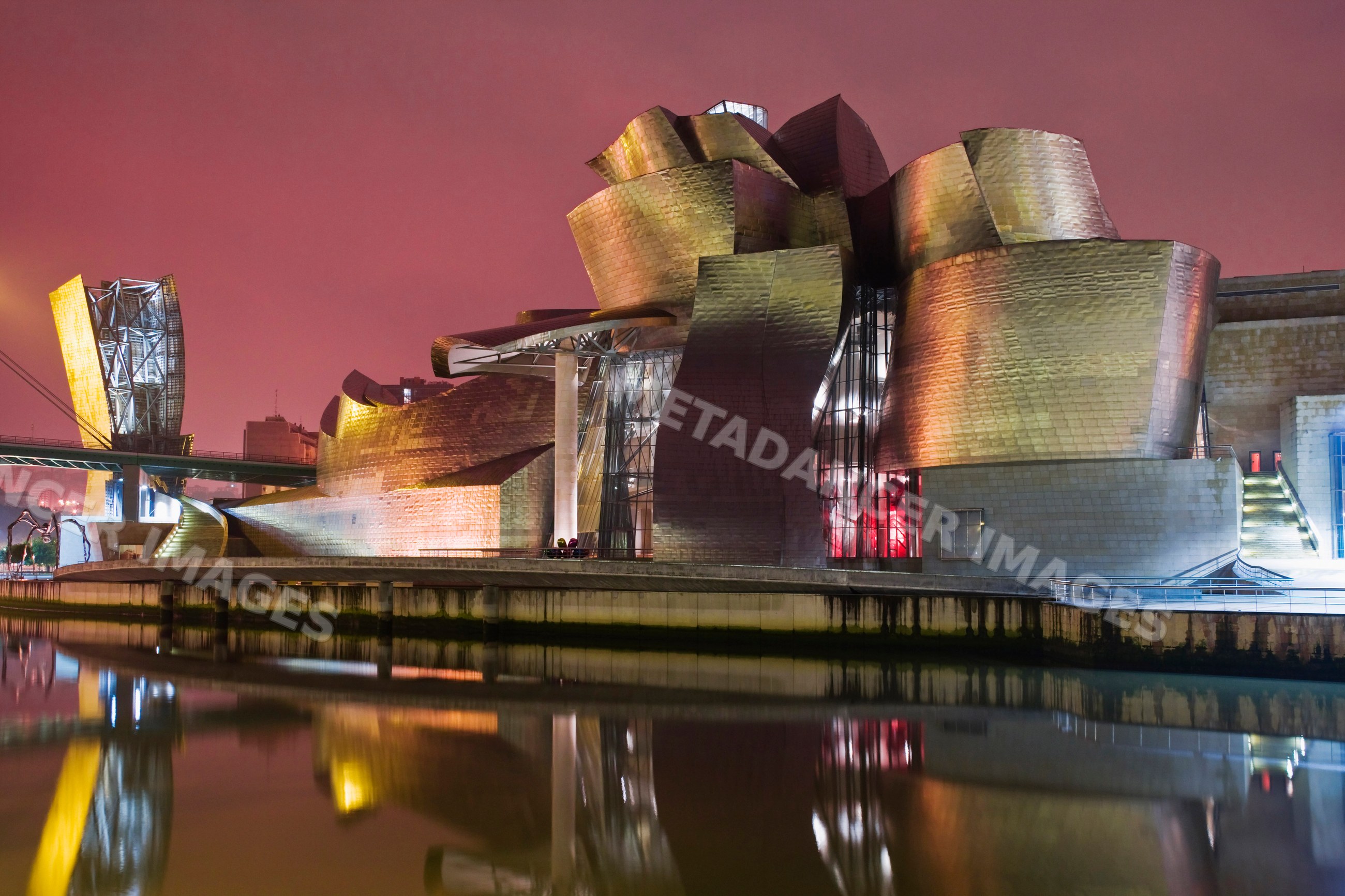 Guggenheim museum bilbao at night with river reflection