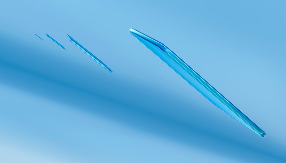 Blue translucent glass shards scattered on smooth blue surface