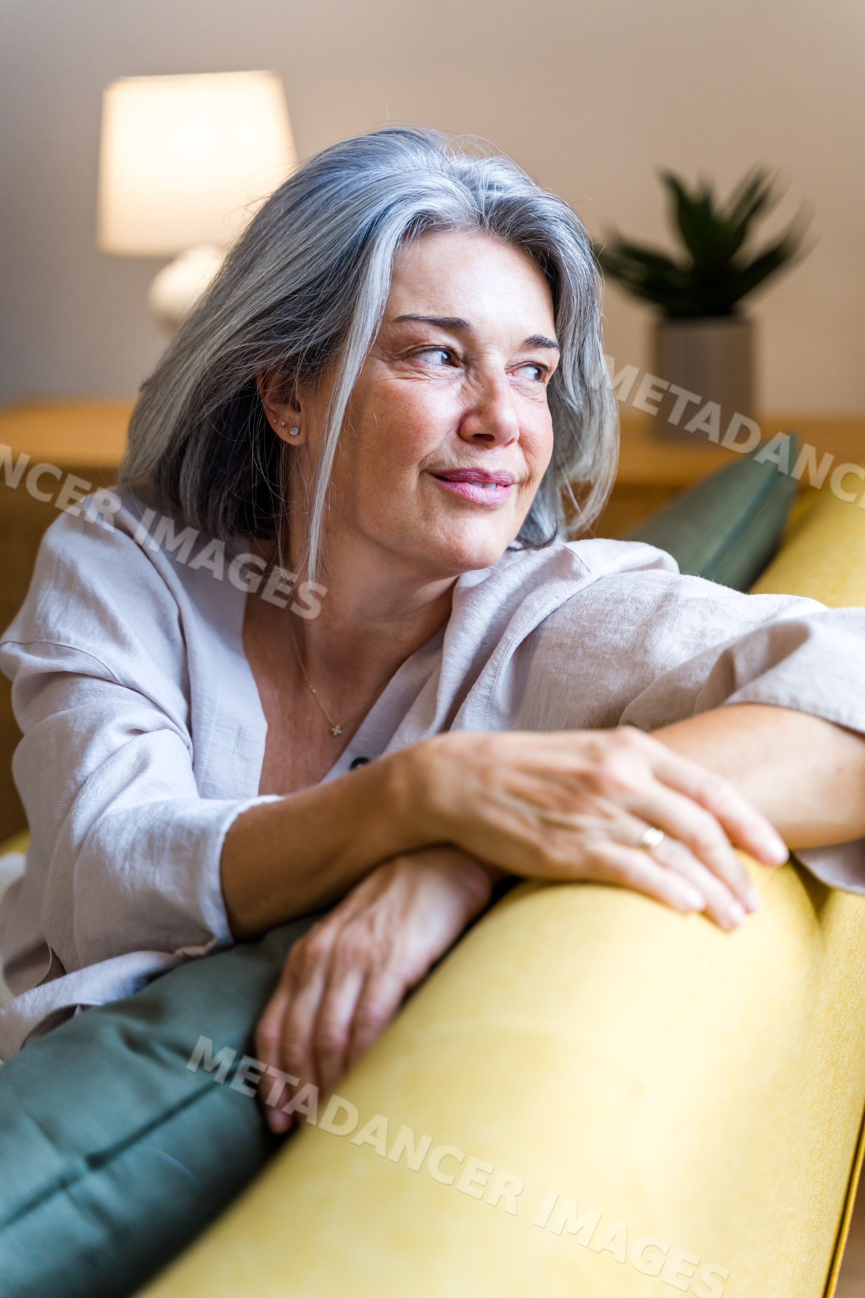 Mature white woman relaxing on sofa indoors