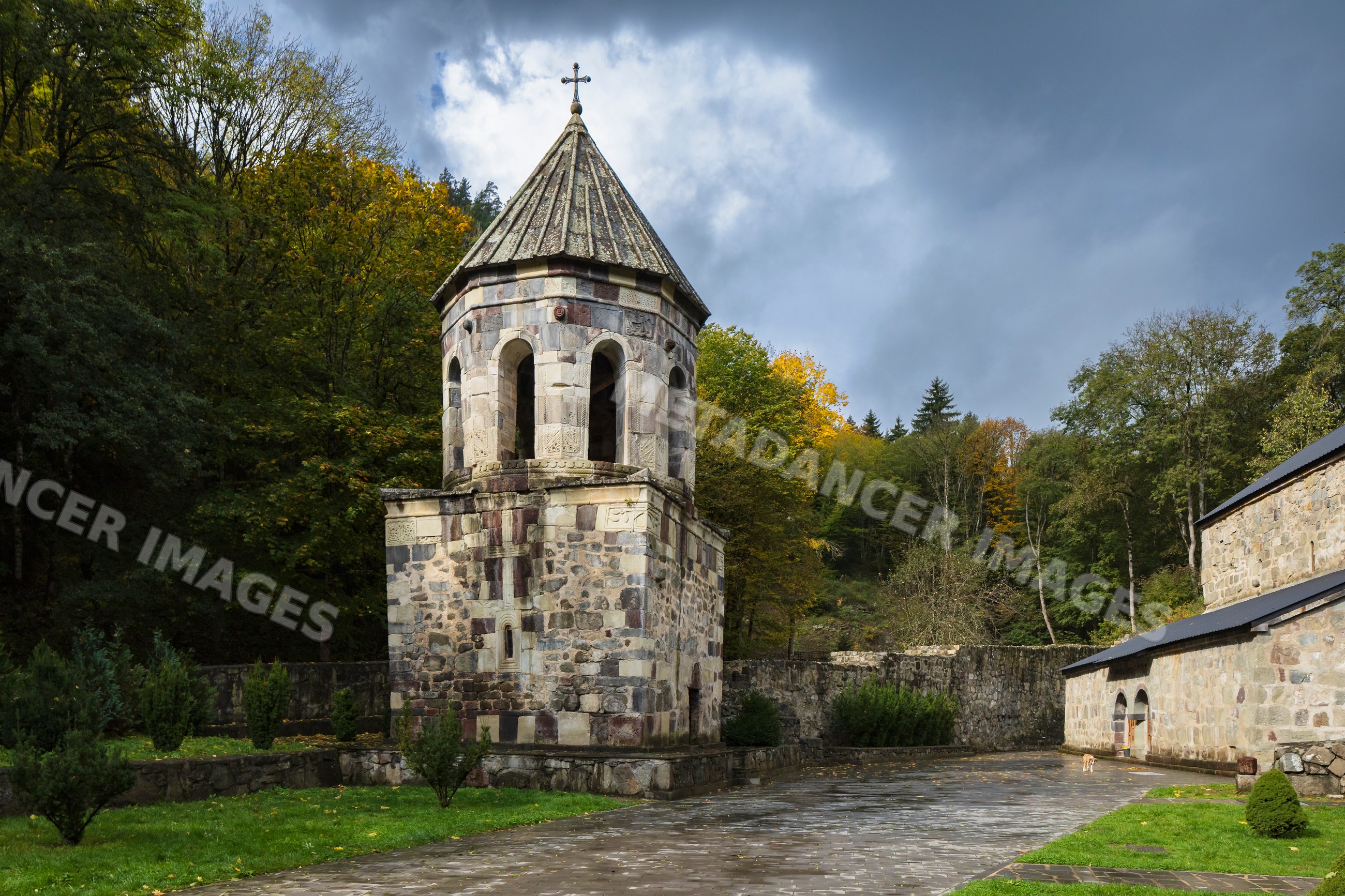 Green monastery bell tower surrounded by autumn forest in chitakhevi