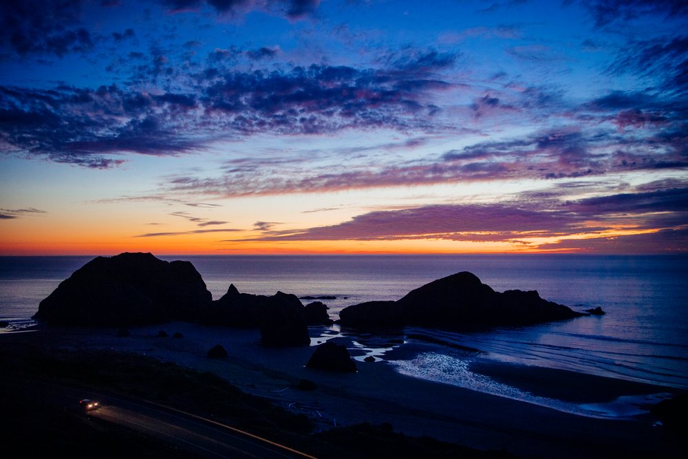 Sunset over rocky ocean coastline and coastal road at meyers creek
