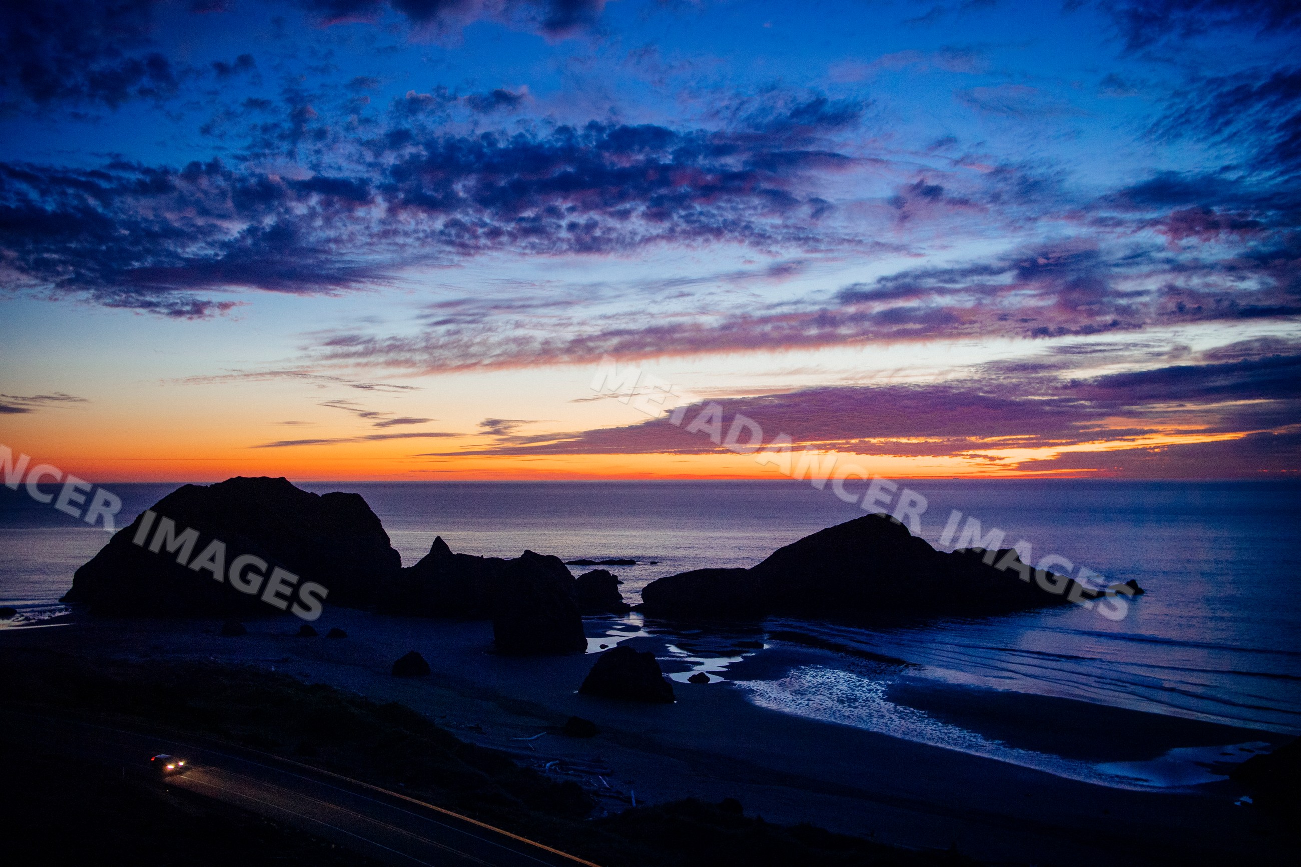 Sunset over rocky ocean coastline and coastal road at meyers creek